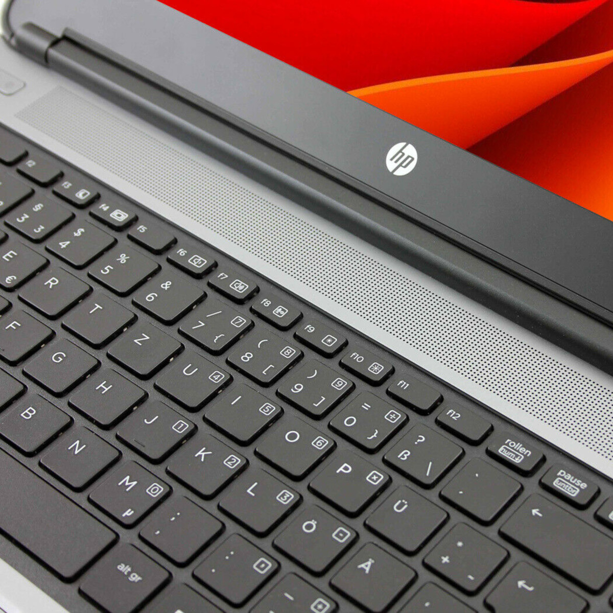 Nahaufnahme einer schwarzen Laptop-Tastatur mit HP-Logo und rotem Hintergrund.