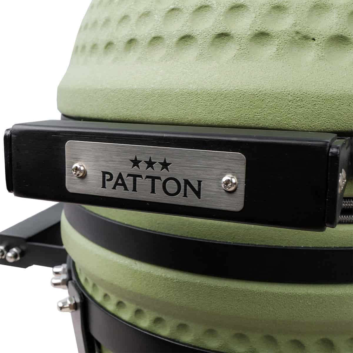 Nahaufnahme eines grünen Keramikgrills mit schwarzer Halterung und silberner PATTON-Logoplatte.
