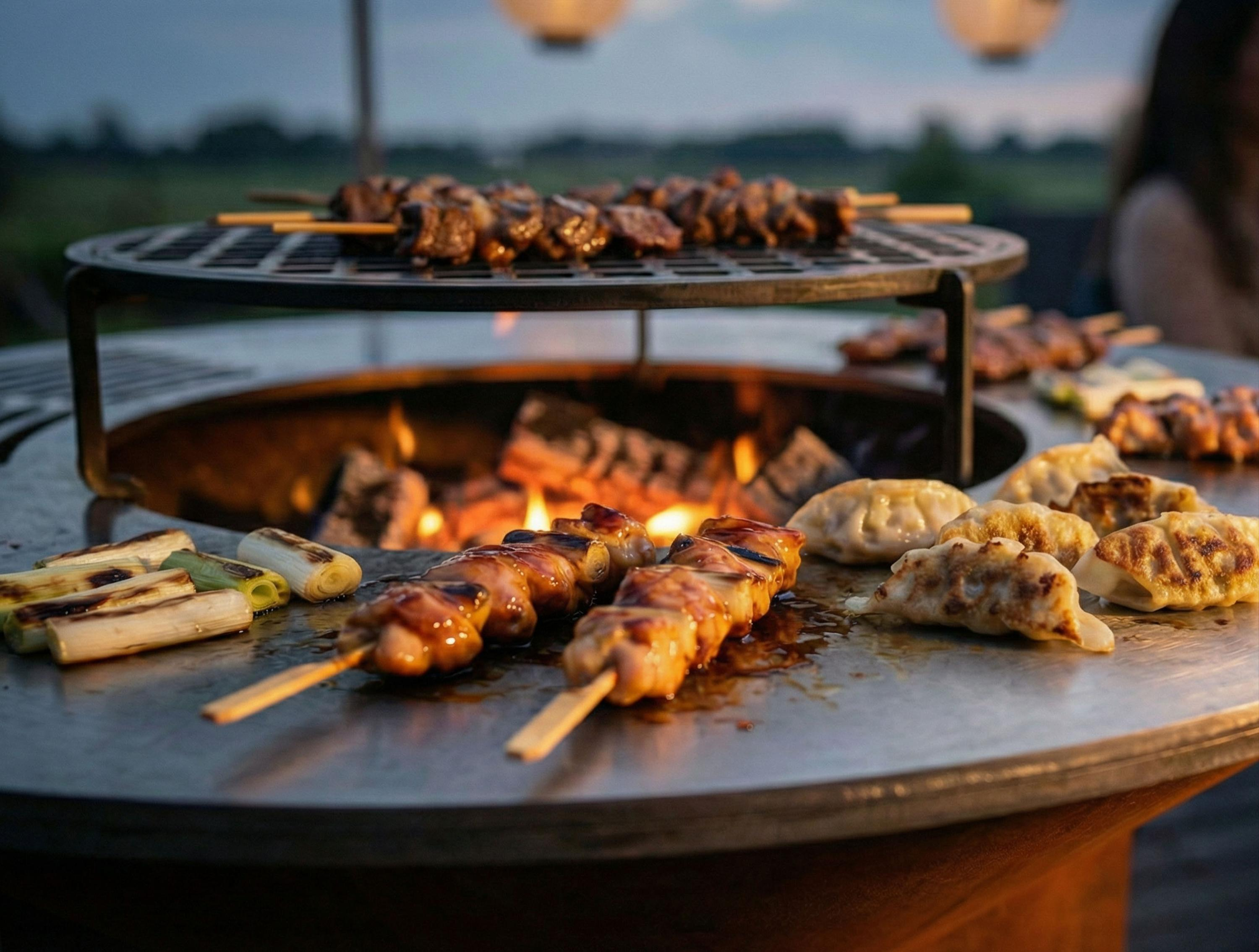Spiedini di carne e gyoza vengono cotti su una griglia a fuoco vivo.