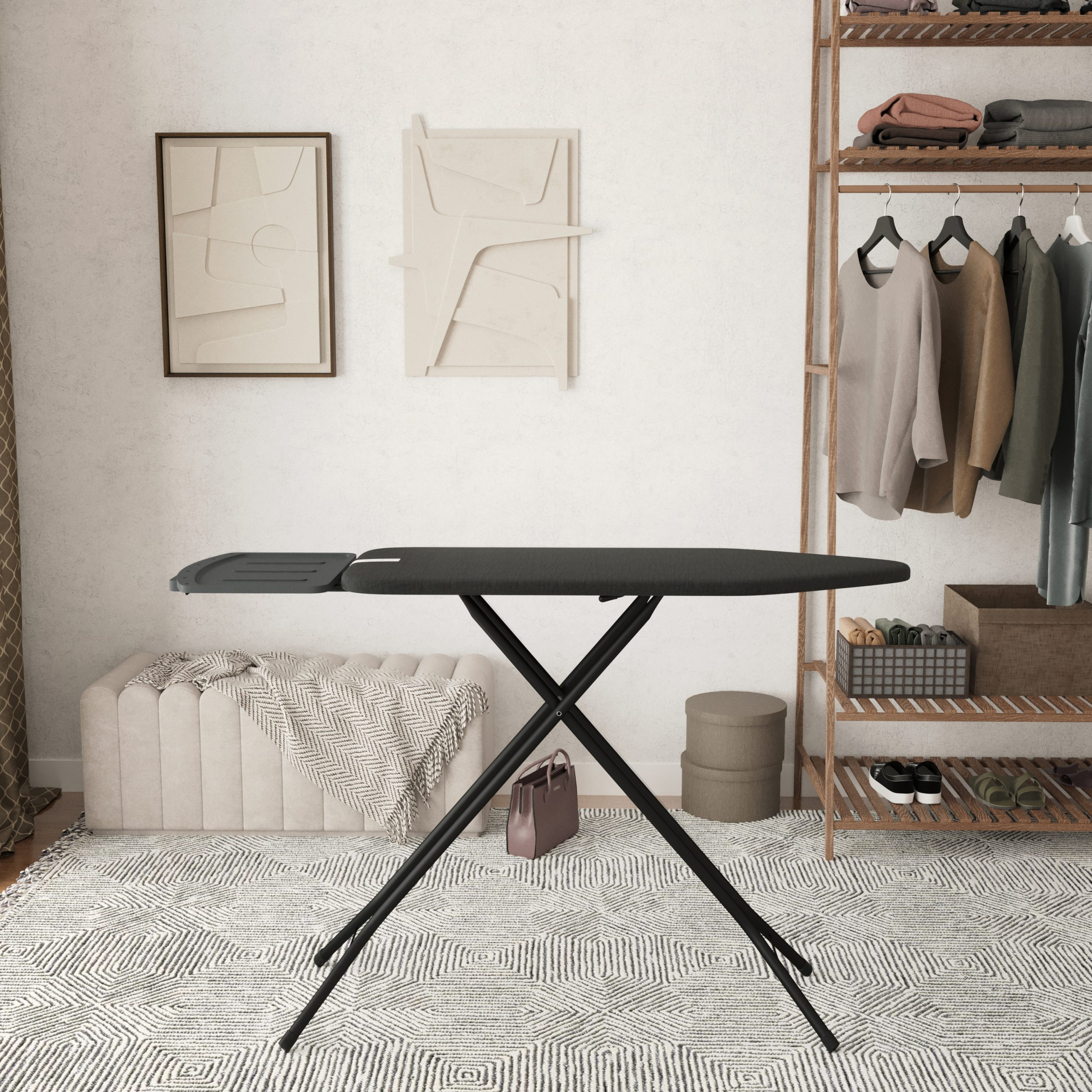 A dark ironing board stands on a rug with a geometric pattern.