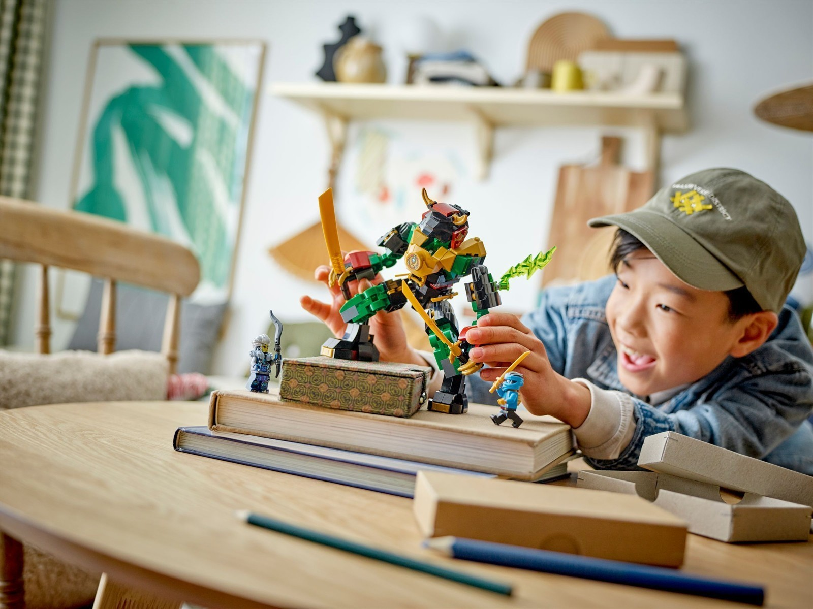 Junge spielt mit Lego-Roboter und Figuren auf einem Tisch.
