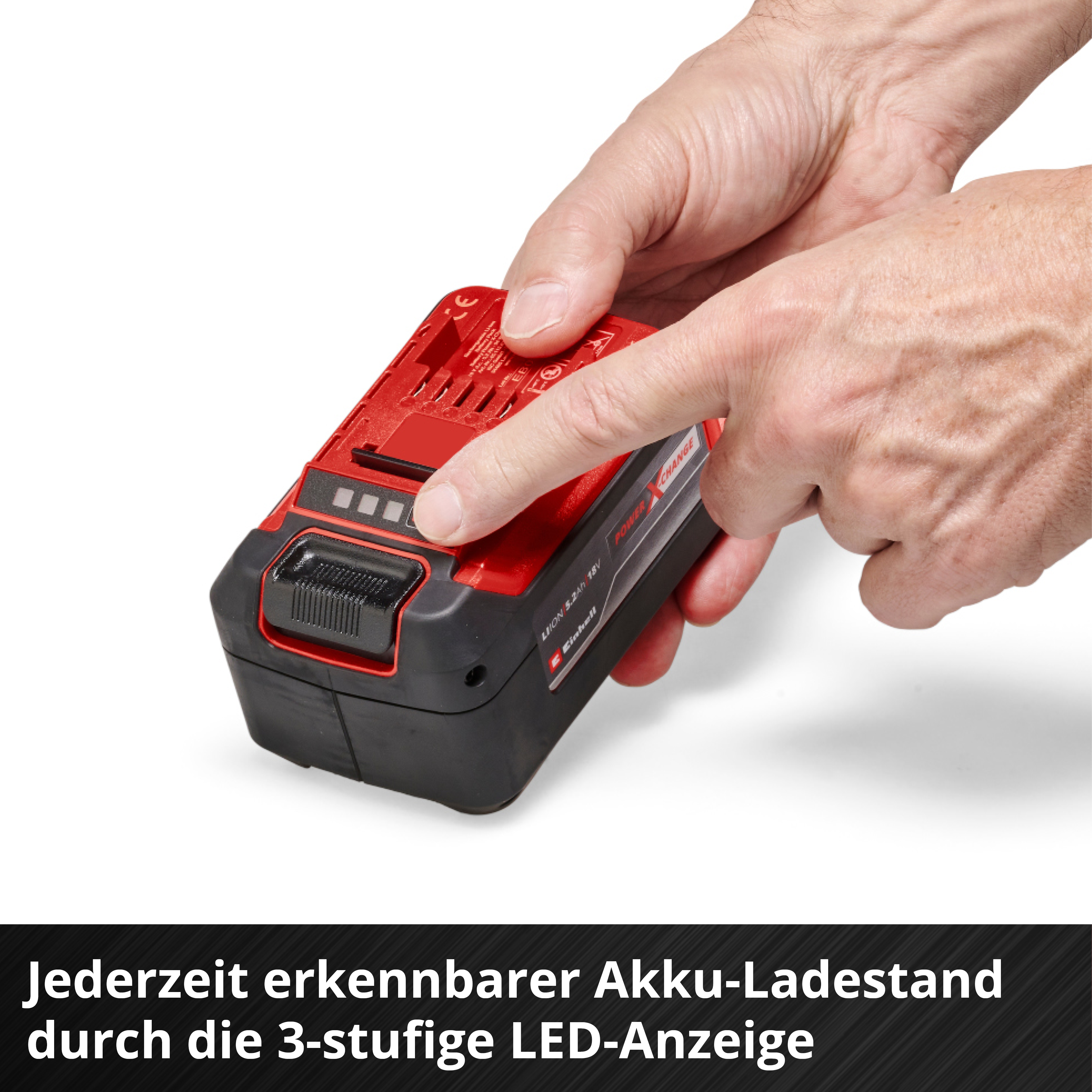 Hände halten einen roten Akku mit schwarzem Gehäuse und 3 LEDs.