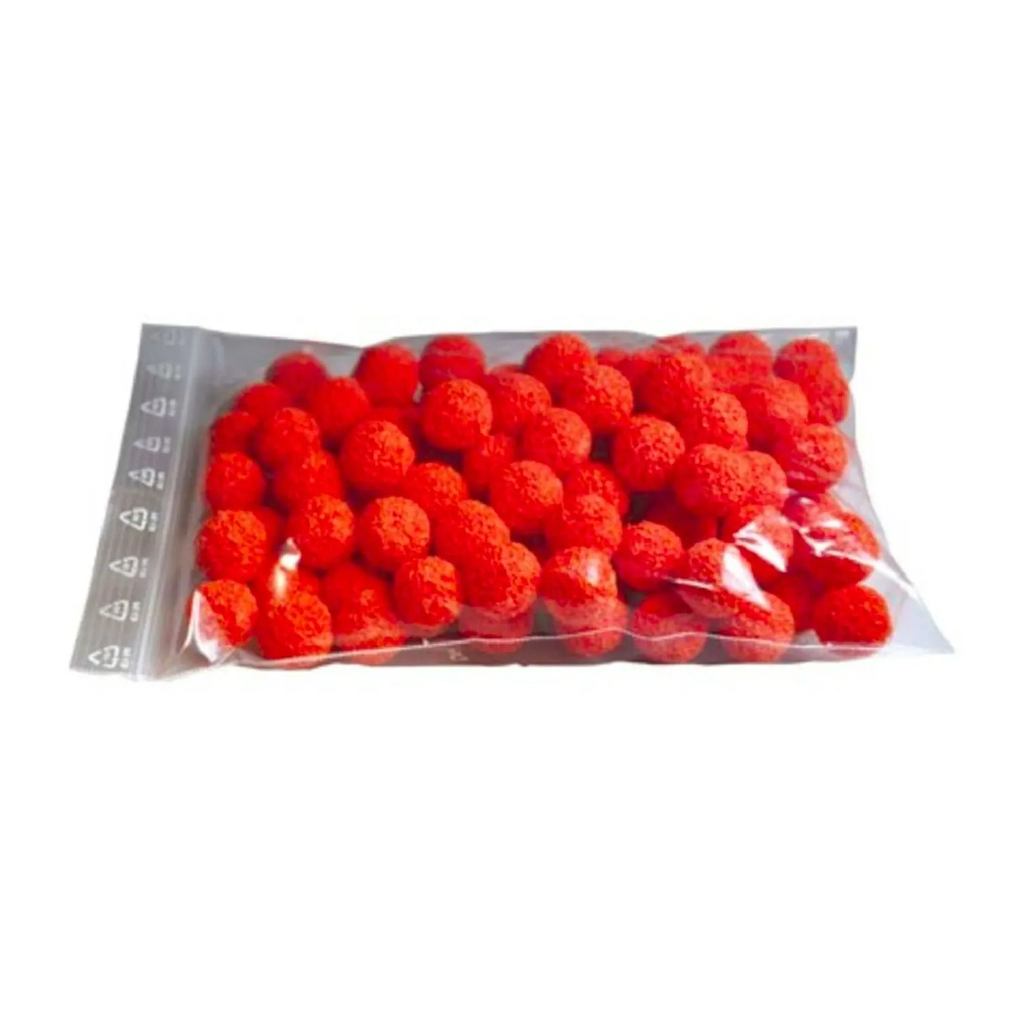 Een doorzichtige zak gevuld met kleine oranje balletjes op witte achtergrond.
