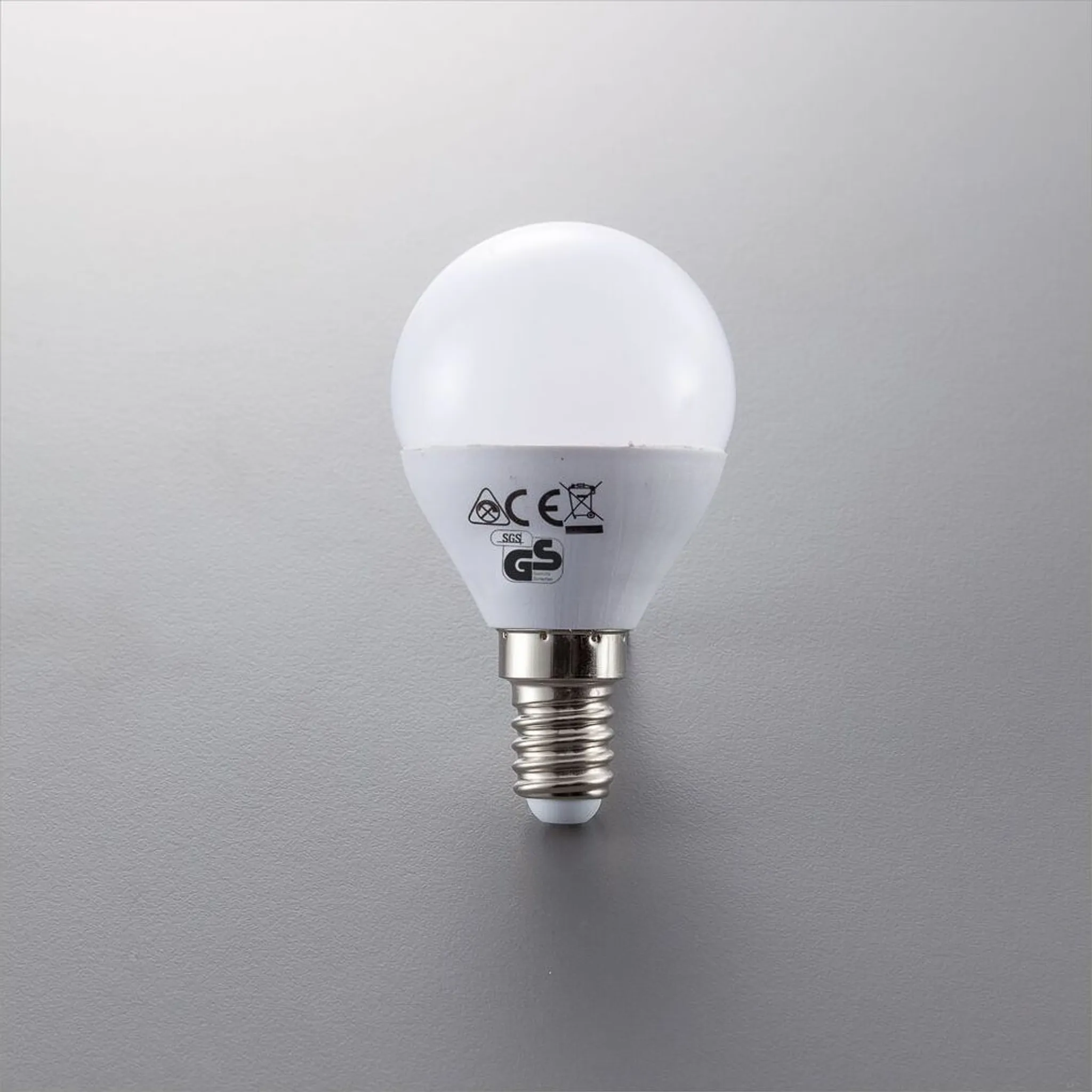 Eine weiße LED-Lampe mit E14-Sockel und CE- und GS-Zertifizierungszeichen.