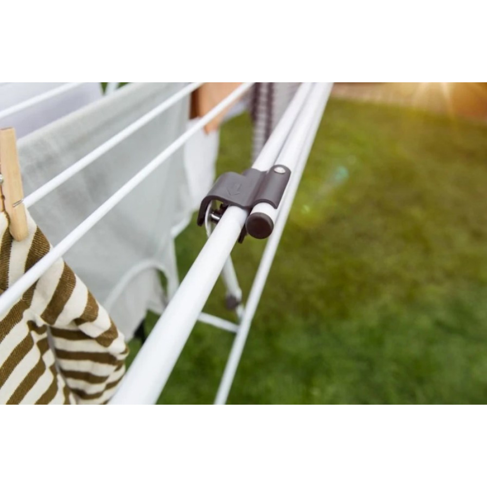 Suszarka na ubrania z praniem na zewnątrz, z trawą w tle.