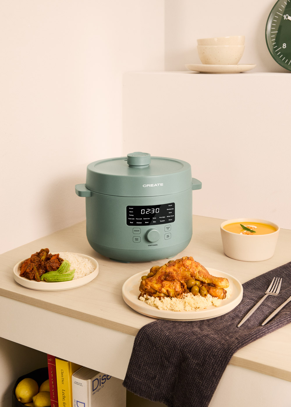 Una olla verde con comida y sopa sobre una mesa.