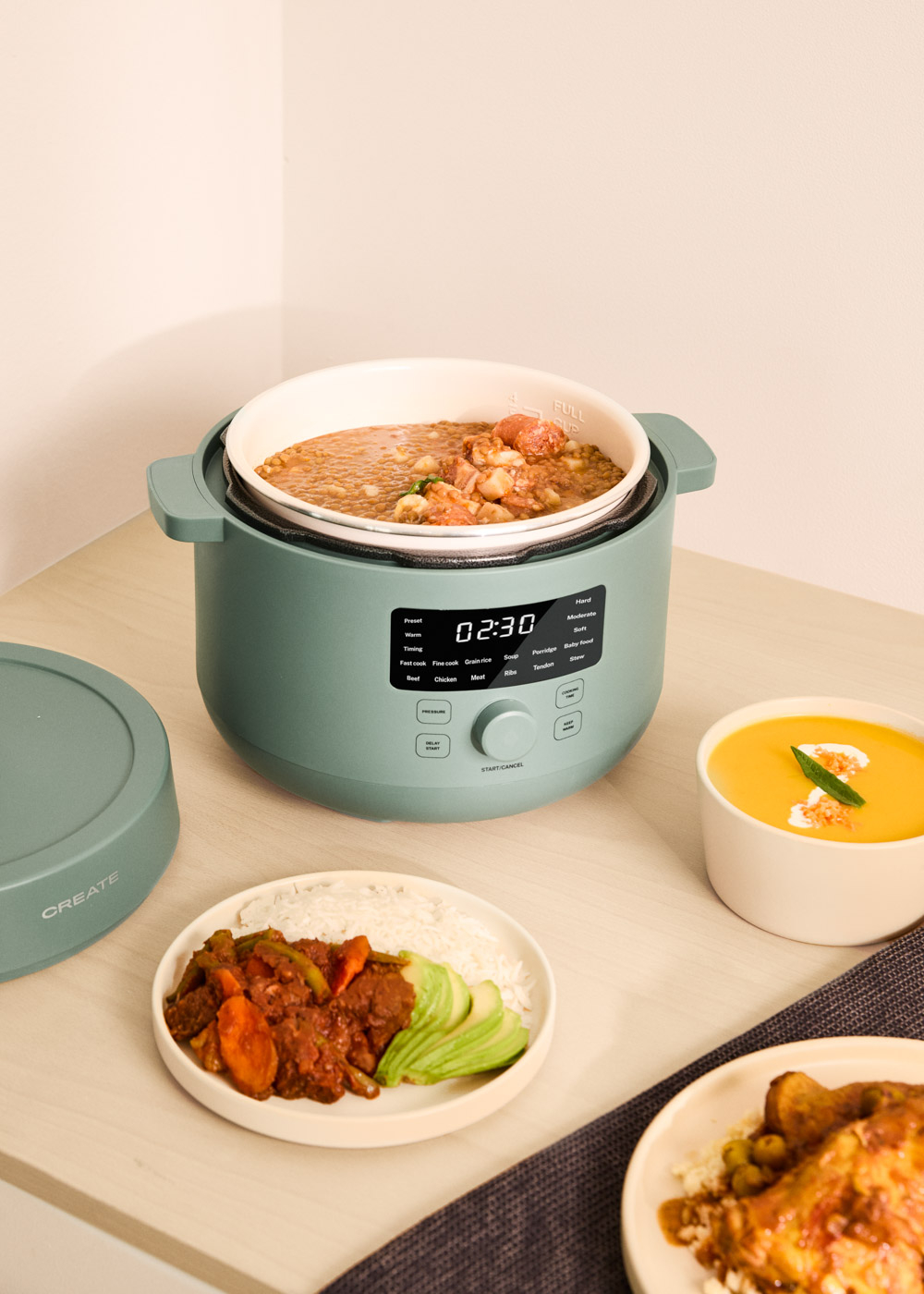 Una olla verde con lentejas, carne y verduras. Platos de arroz y pollo están cerca.