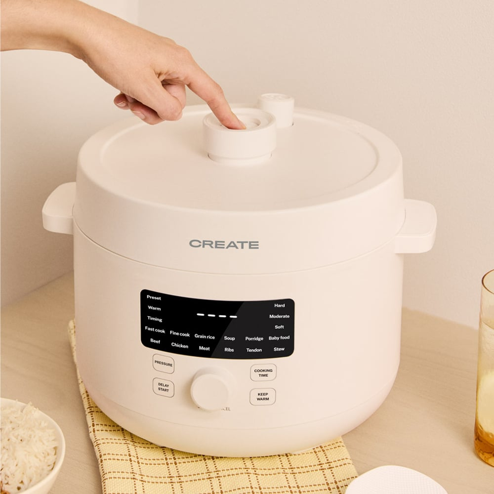 Una máquina de cocina blanca con panel de control y un dedo presionando un botón.