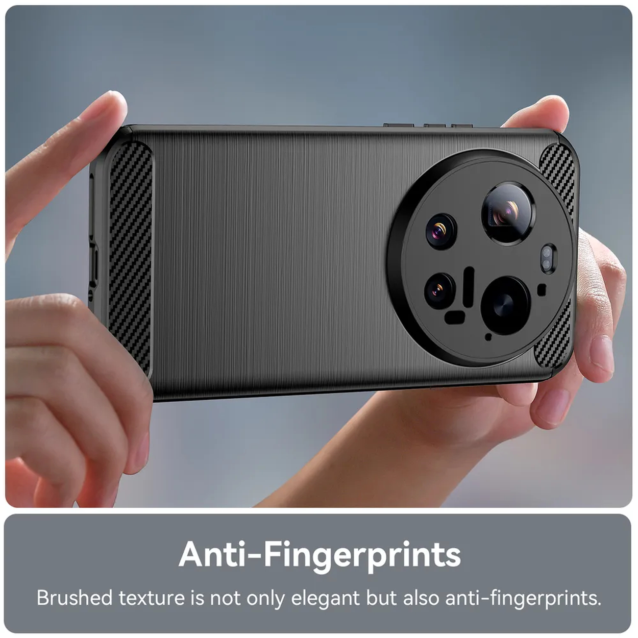 Des mains tiennent un téléphone sombre à texture brossée et module caméra proéminent.