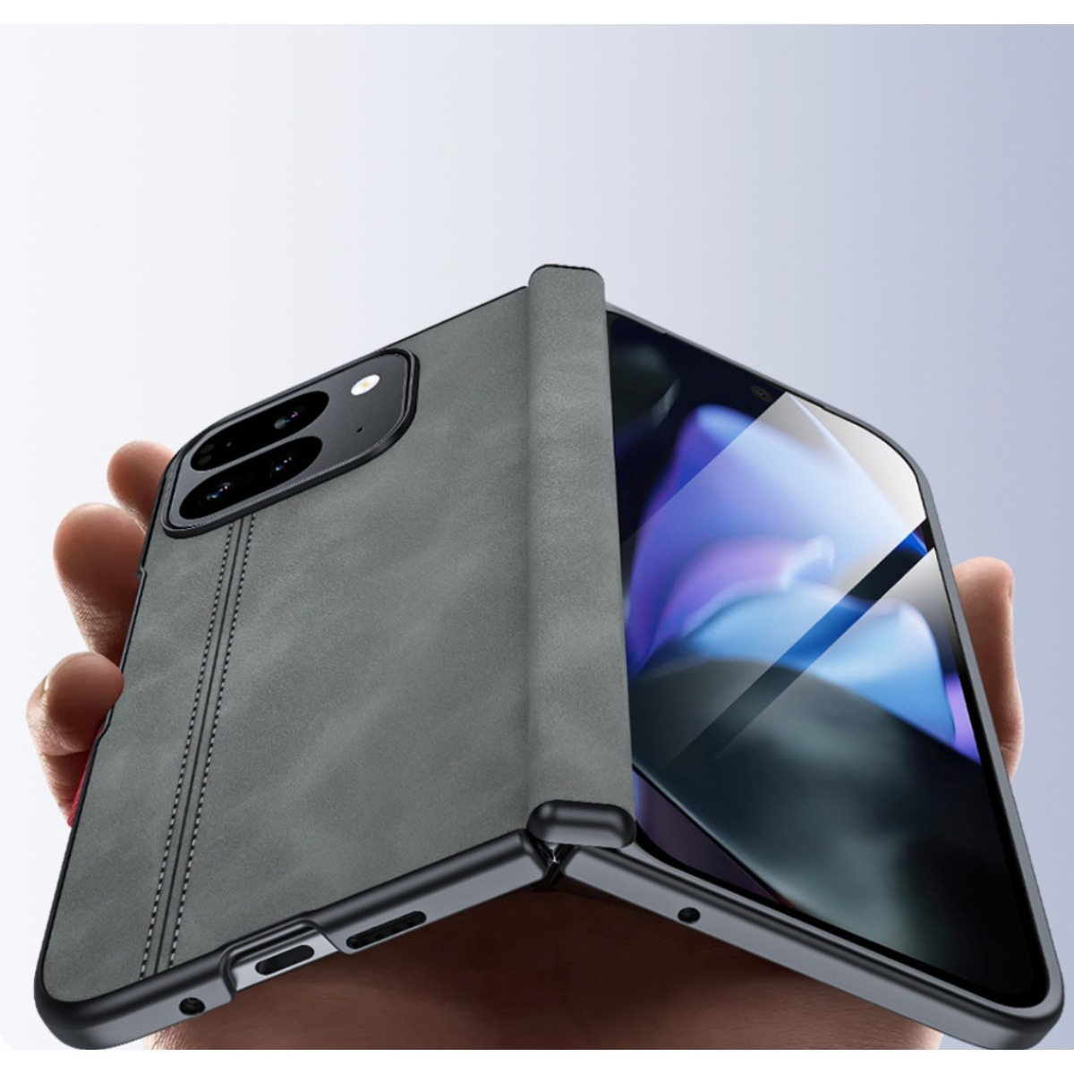 Una mano tiene un telefono grigio con retro cucito e schermo pieghevole.