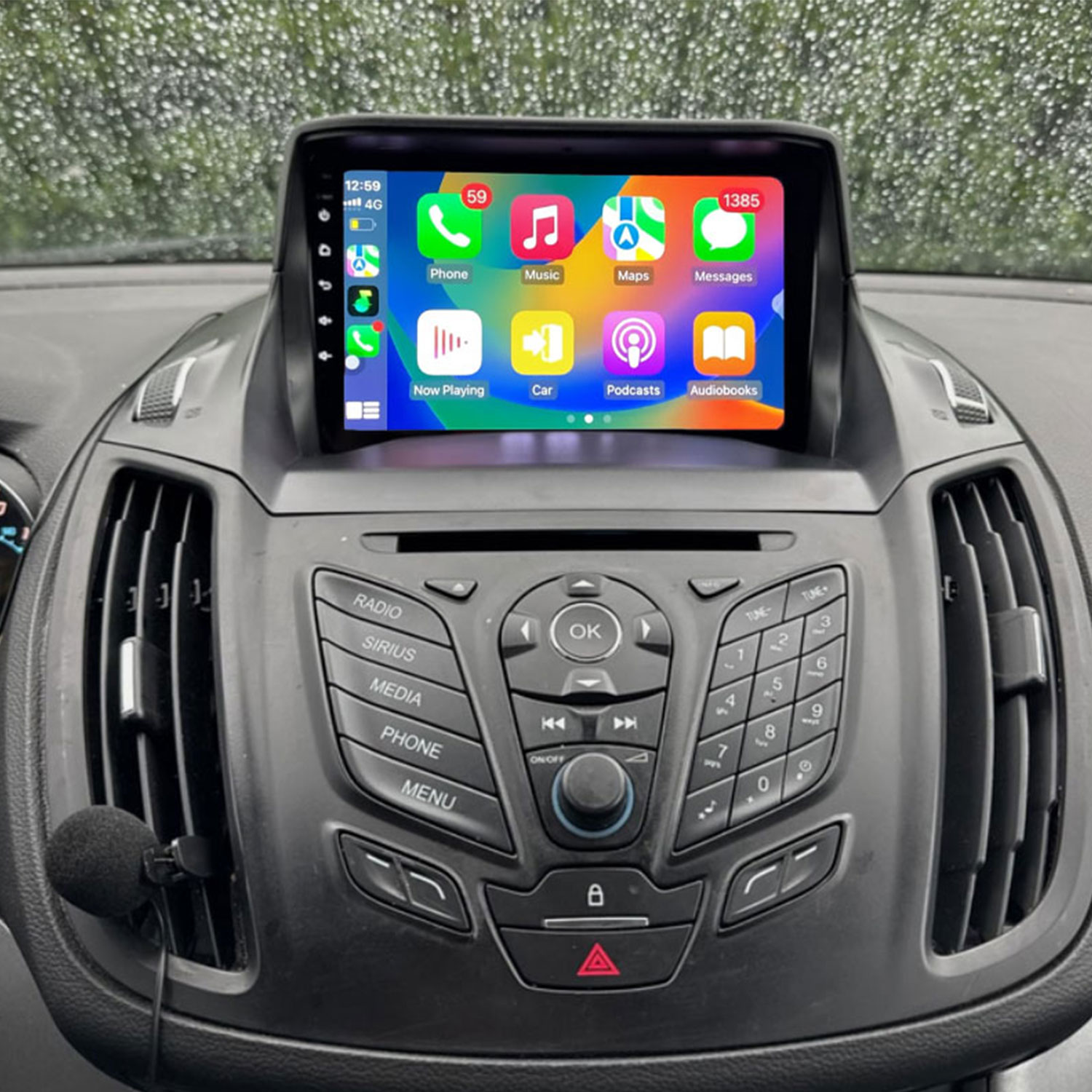 Ein Auto-Infotainmentsystem mit einem Touchscreen zeigt App-Icons. Regentropfen auf der Windschutzscheibe.