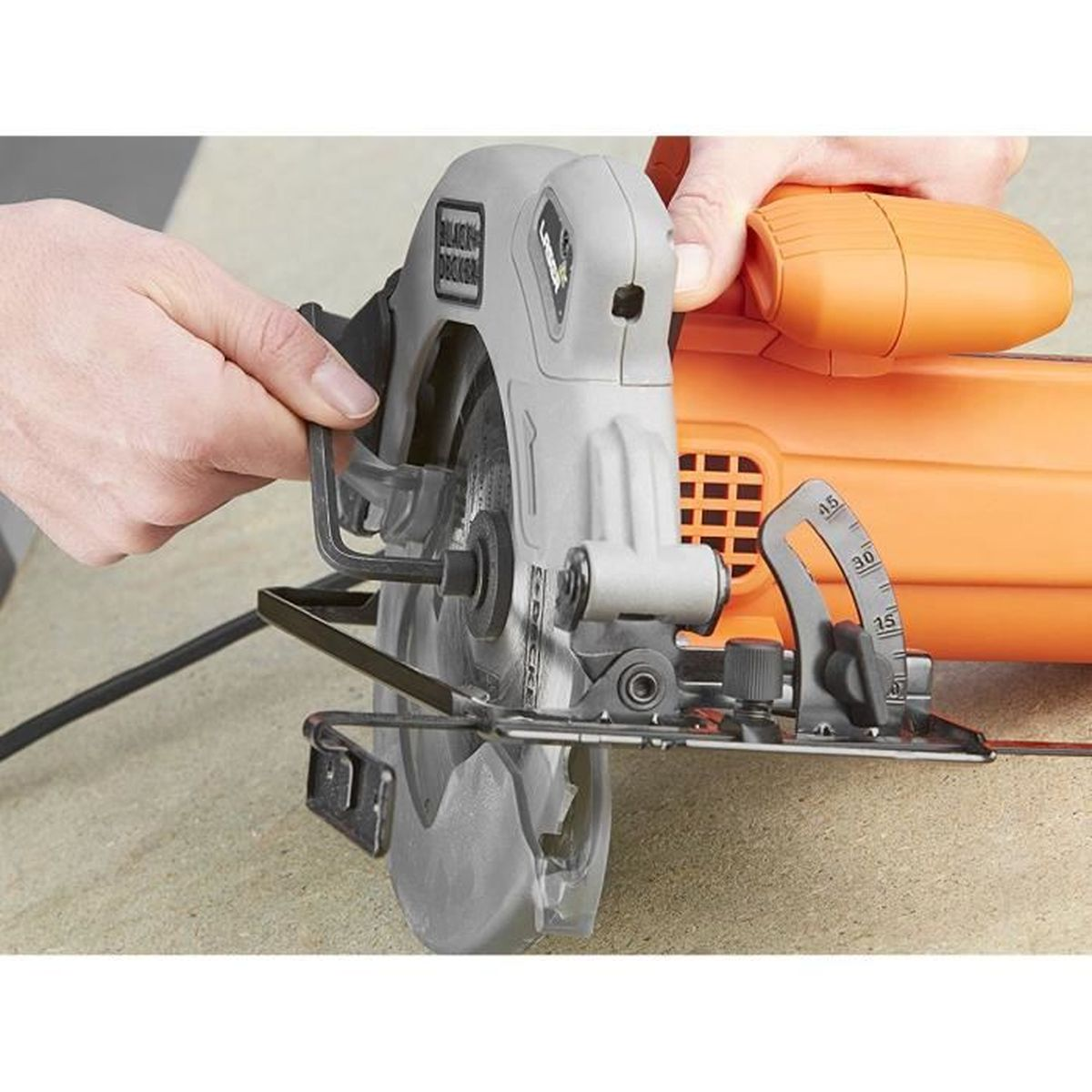 Grauer Kreissägen-Motor mit orangefarbenem Griff wird von Händen gehalten.