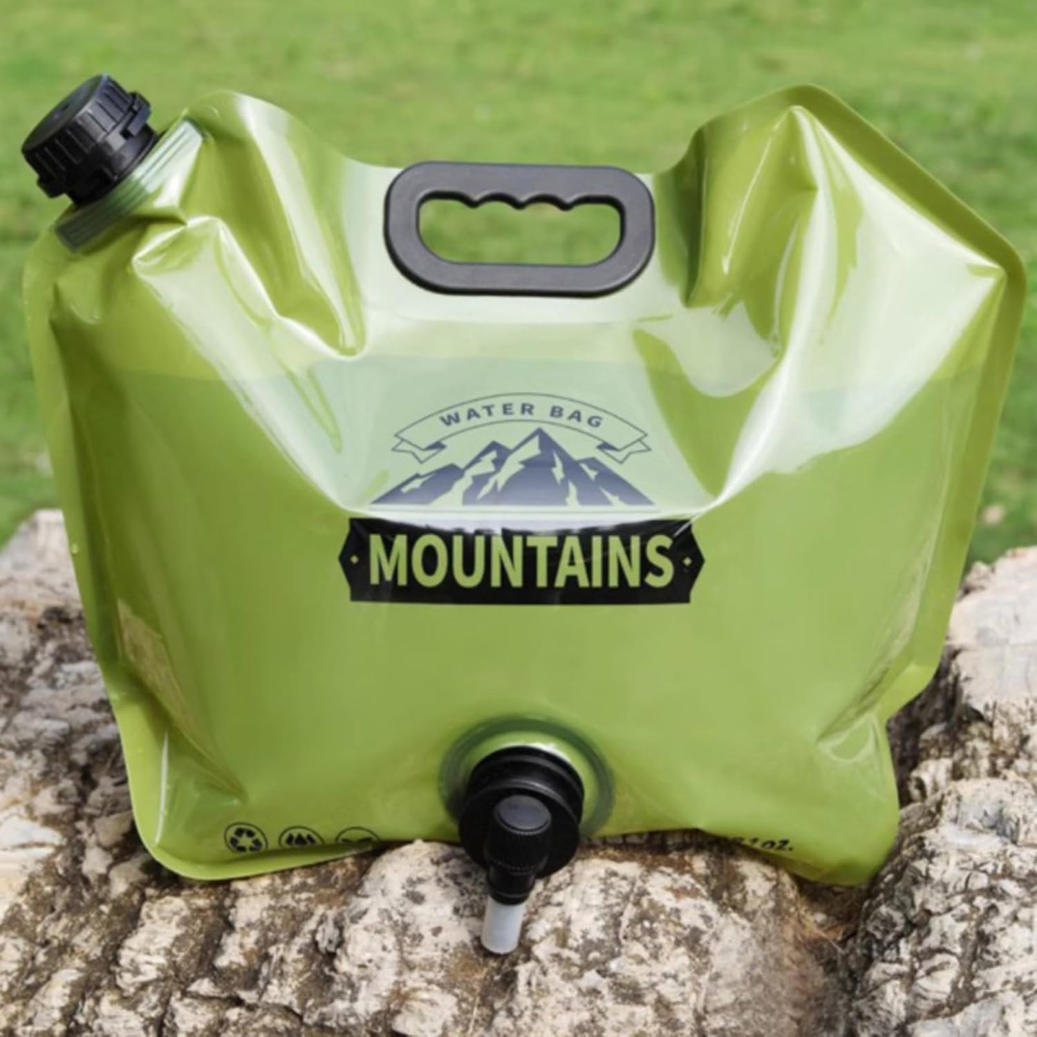 Grüne faltbare Wasserflasche mit Griff und Auslauf auf Felsen.