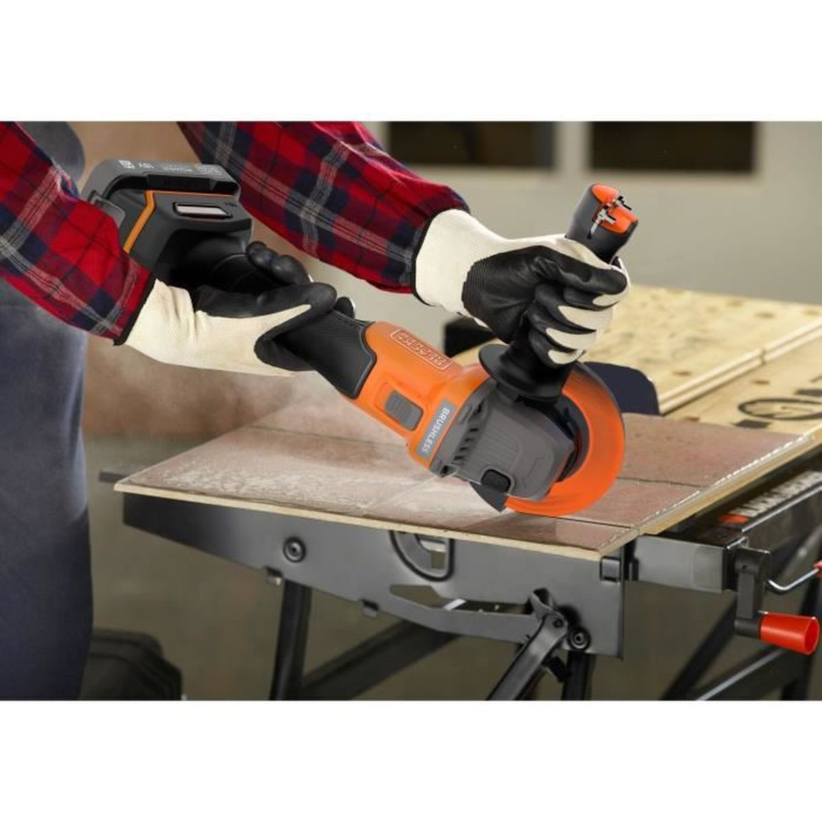Person mit Schutzhandschuhen schneidet Fliese mit Winkelschleifer.