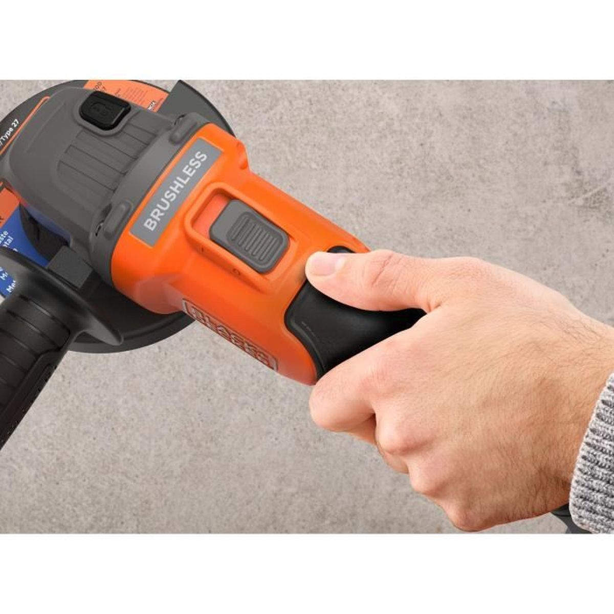 Eine Hand hält einen orangefarbenen Winkelschleifer mit "BRUSHLESS"-Aufschrift.