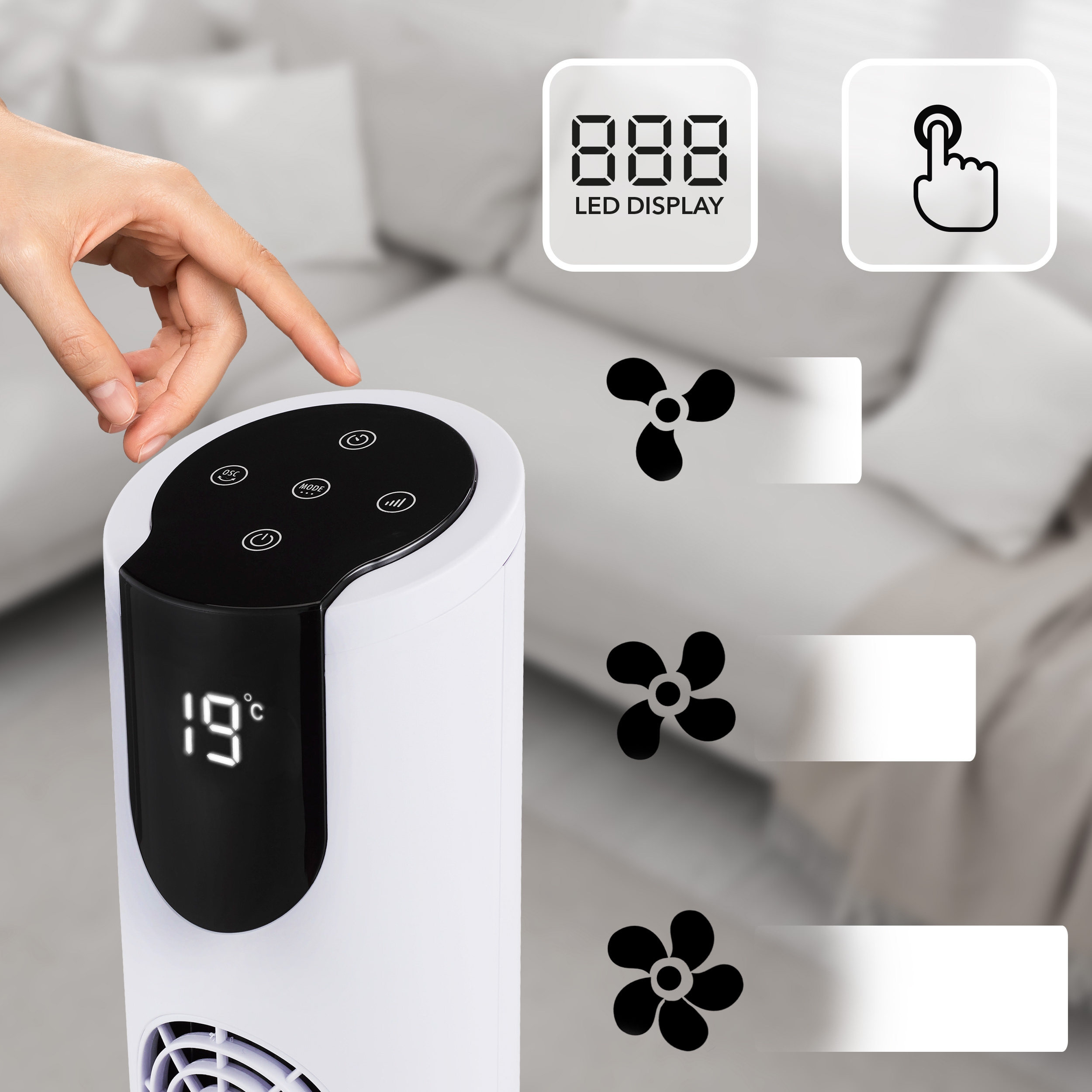 Dłoń naciska na biały wentylator wieżowy z wyświetlaczem LED.