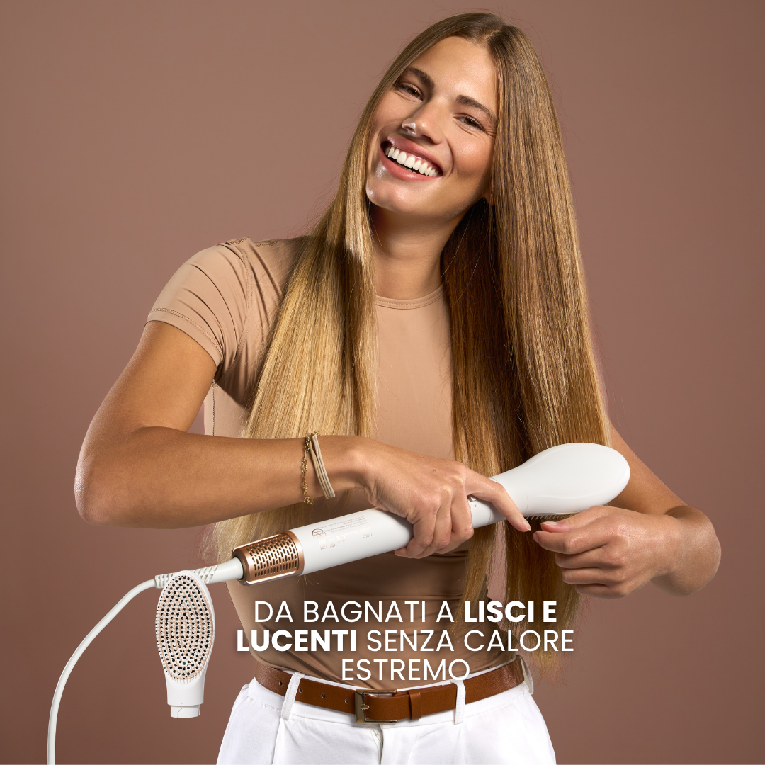 Donna sorridente con lunghi capelli biondi usa un styler bianco e oro. Sfondo marrone.