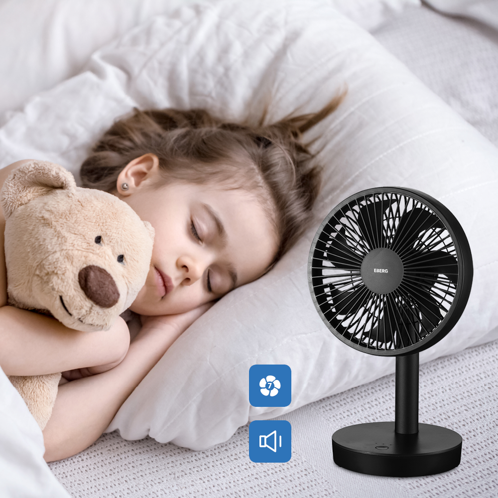 Mała dziewczynka śpi spokojnie z misiem. W pobliżu stoi wentylator.