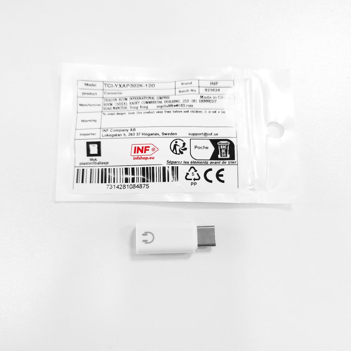 Ein weißer USB-C-Adapter mit einem Ladesymbol auf der Oberseite und Verpackung.