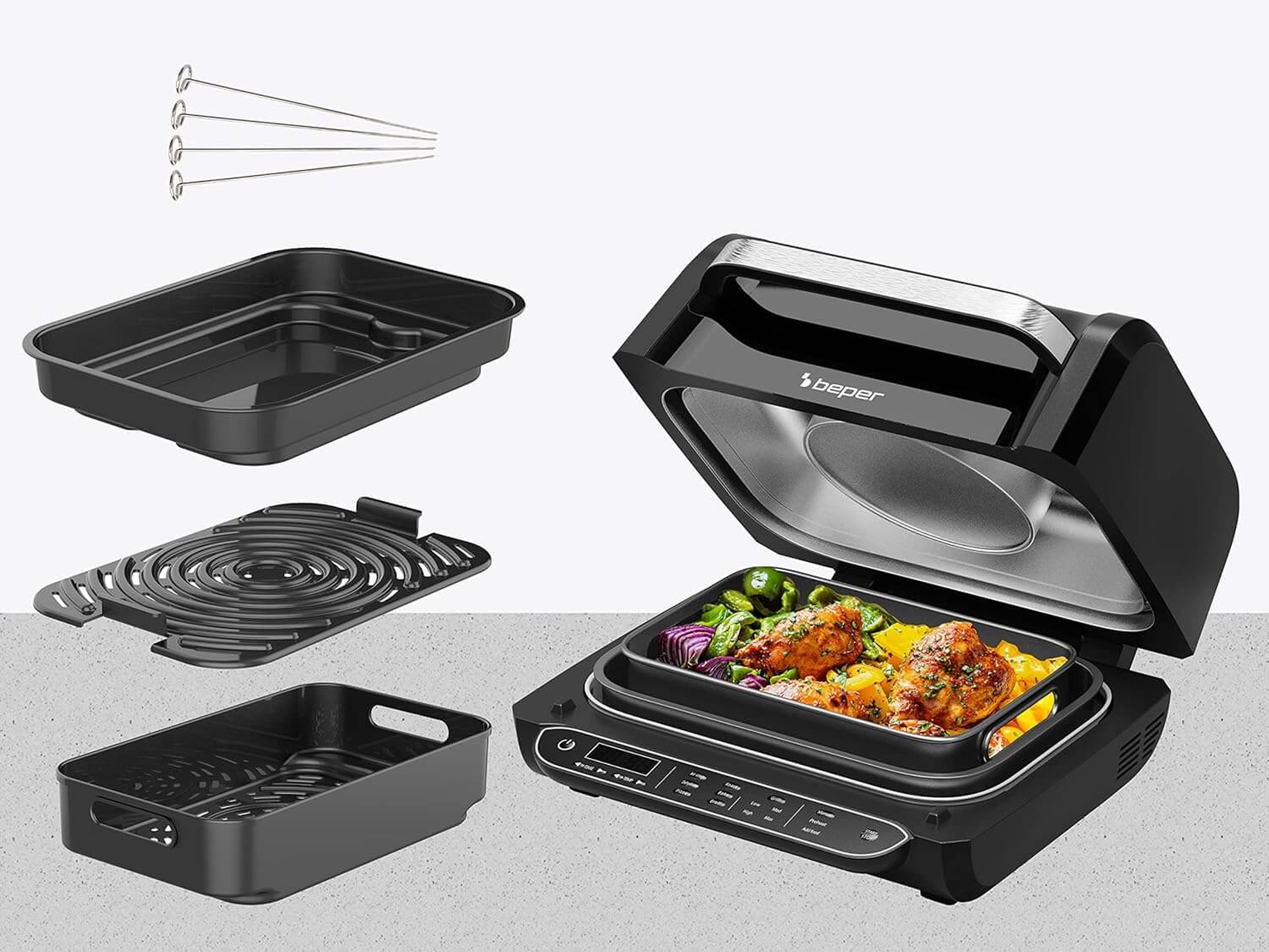 Ein offener schwarzer Tischgrill mit Hähnchen und Gemüse, Zubehör daneben.