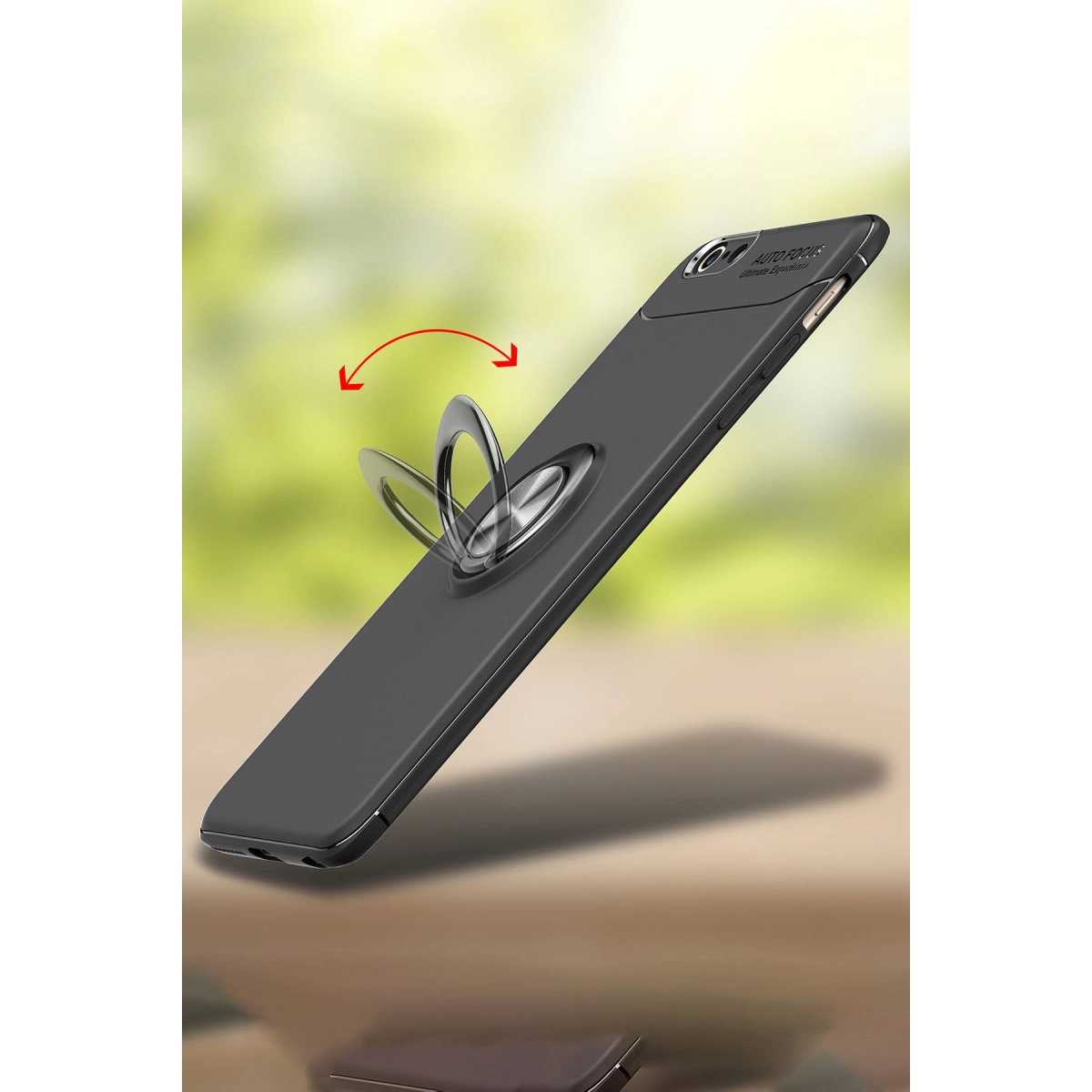 Halka tutuculu siyah telefon kılıfı, yeşil bulanık arka plan.