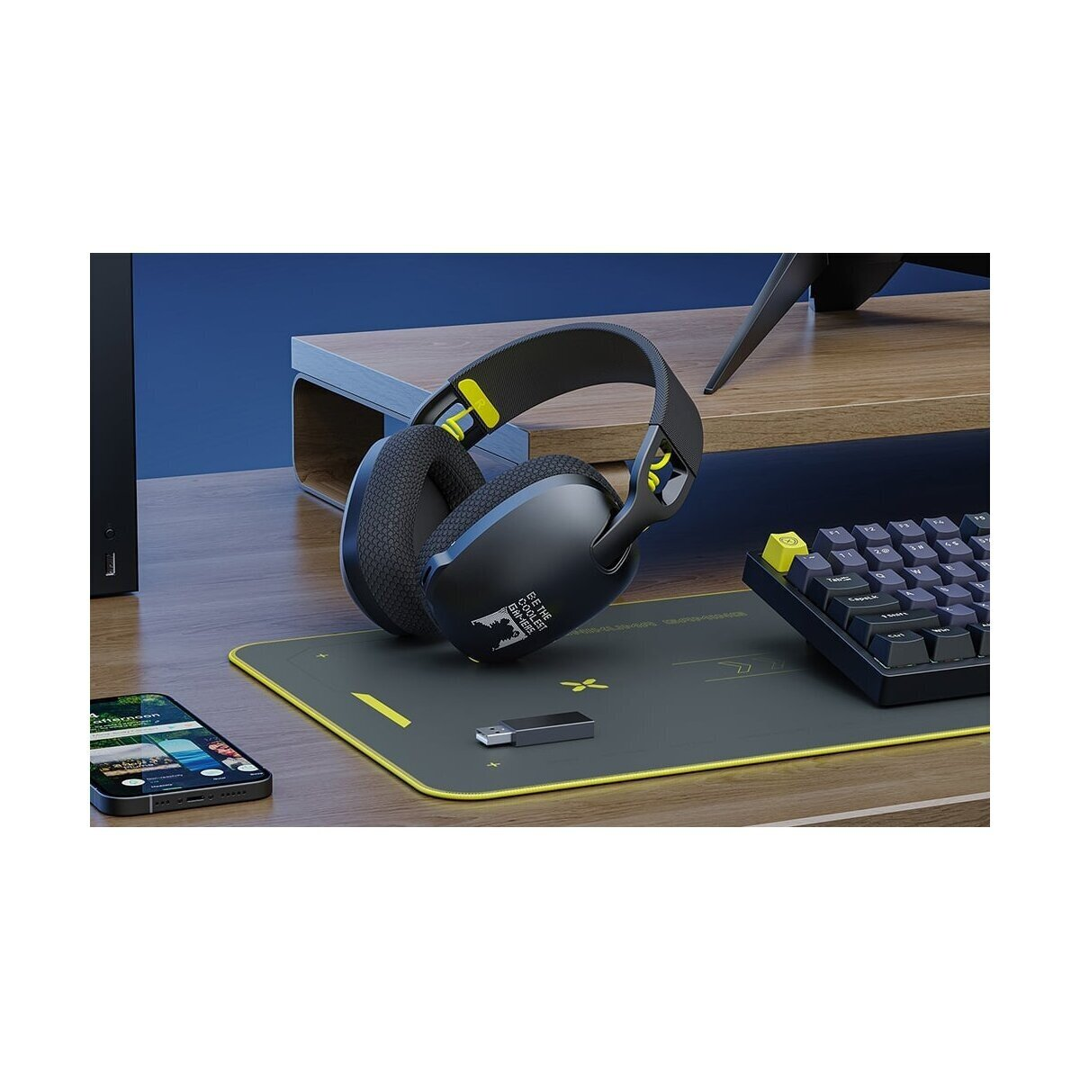 Schwarzer Gaming-Kopfhörer auf einem Schreibtisch mit Handy, Tastatur und USB-Stick.
