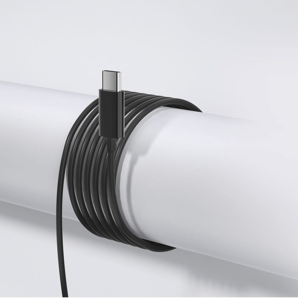 Zwarte USB-C-kabel opgerold rond een witte pijp.