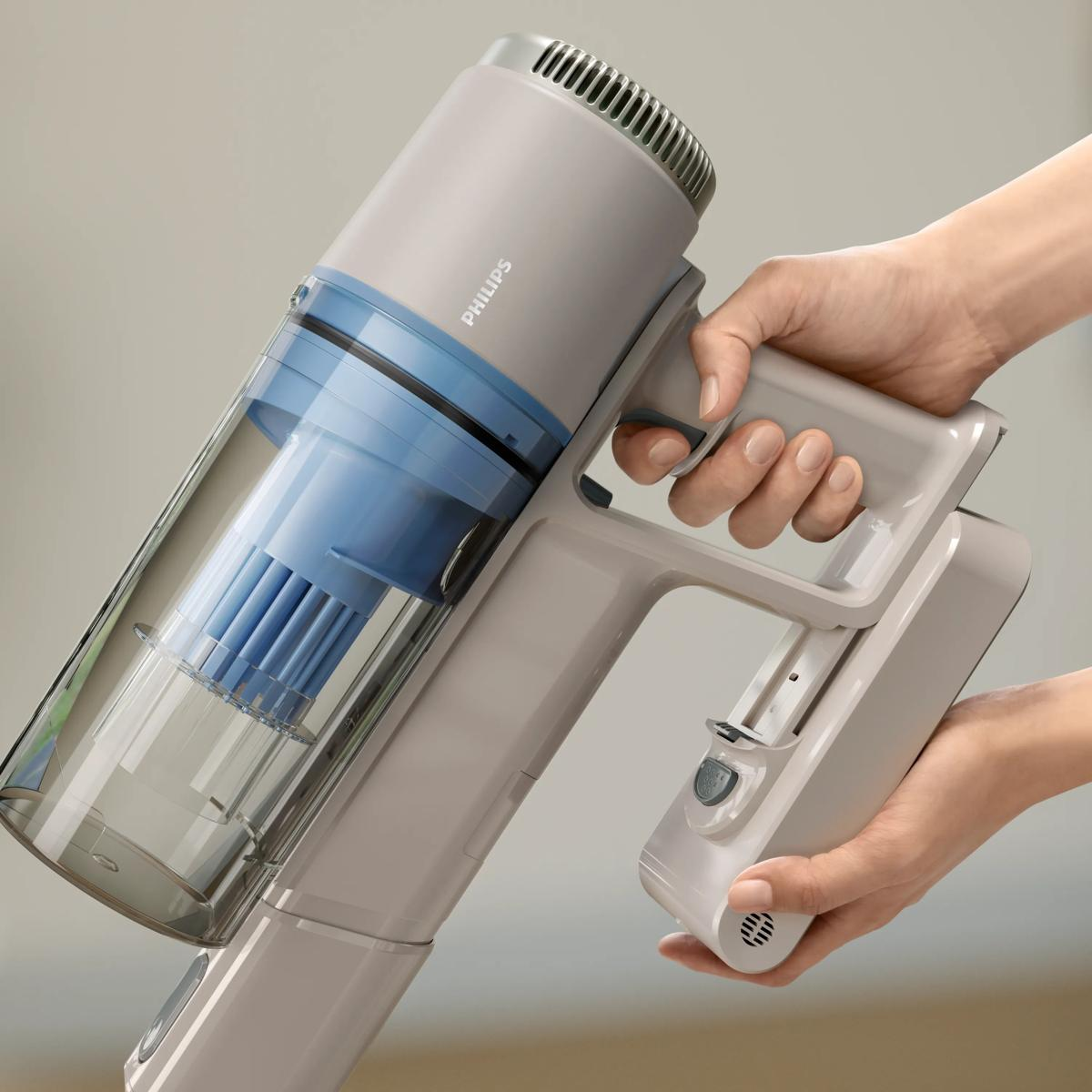 Aspirapolvere Philips grigio con filtro blu, tenuto dalle mani.