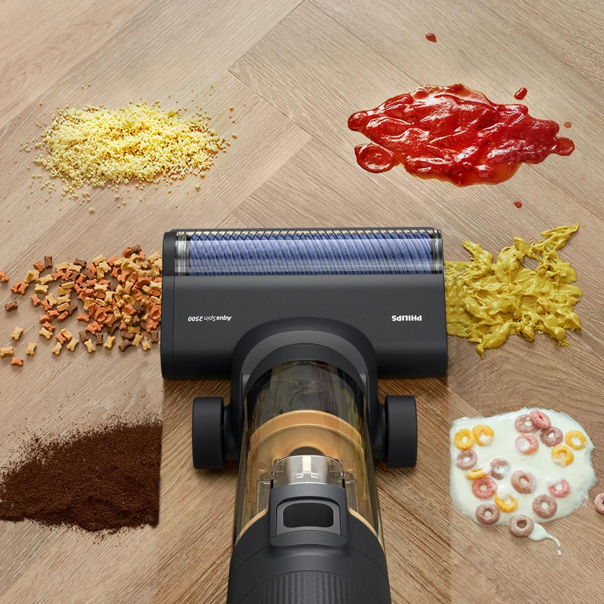 Testina aspirapolvere davanti a versamenti di cereali, caffè, pasta e ketchup.