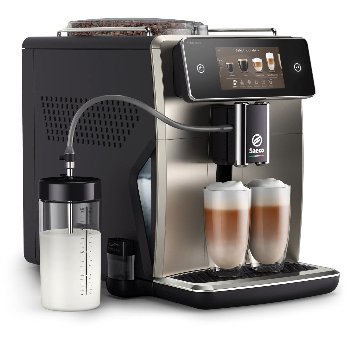 Eine silberne und schwarze Kaffeemaschine mit zwei Gläsern Milchschaumkaffee.