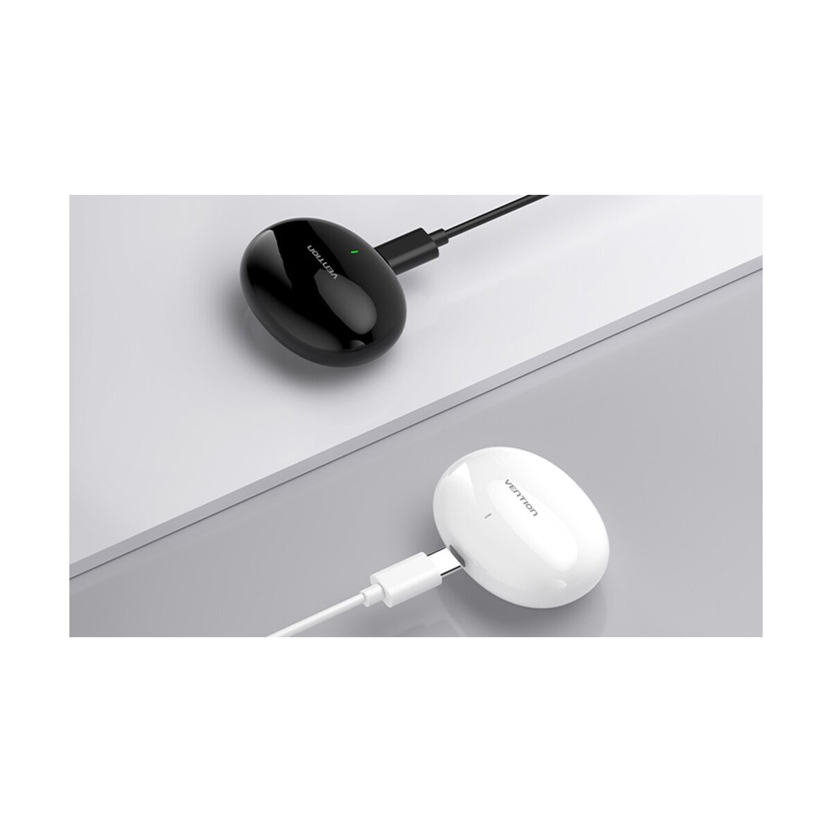 Zwei ovale Ladeboxen, eine schwarz mit grünem Licht, eine weiß. Beide mit Kabel.