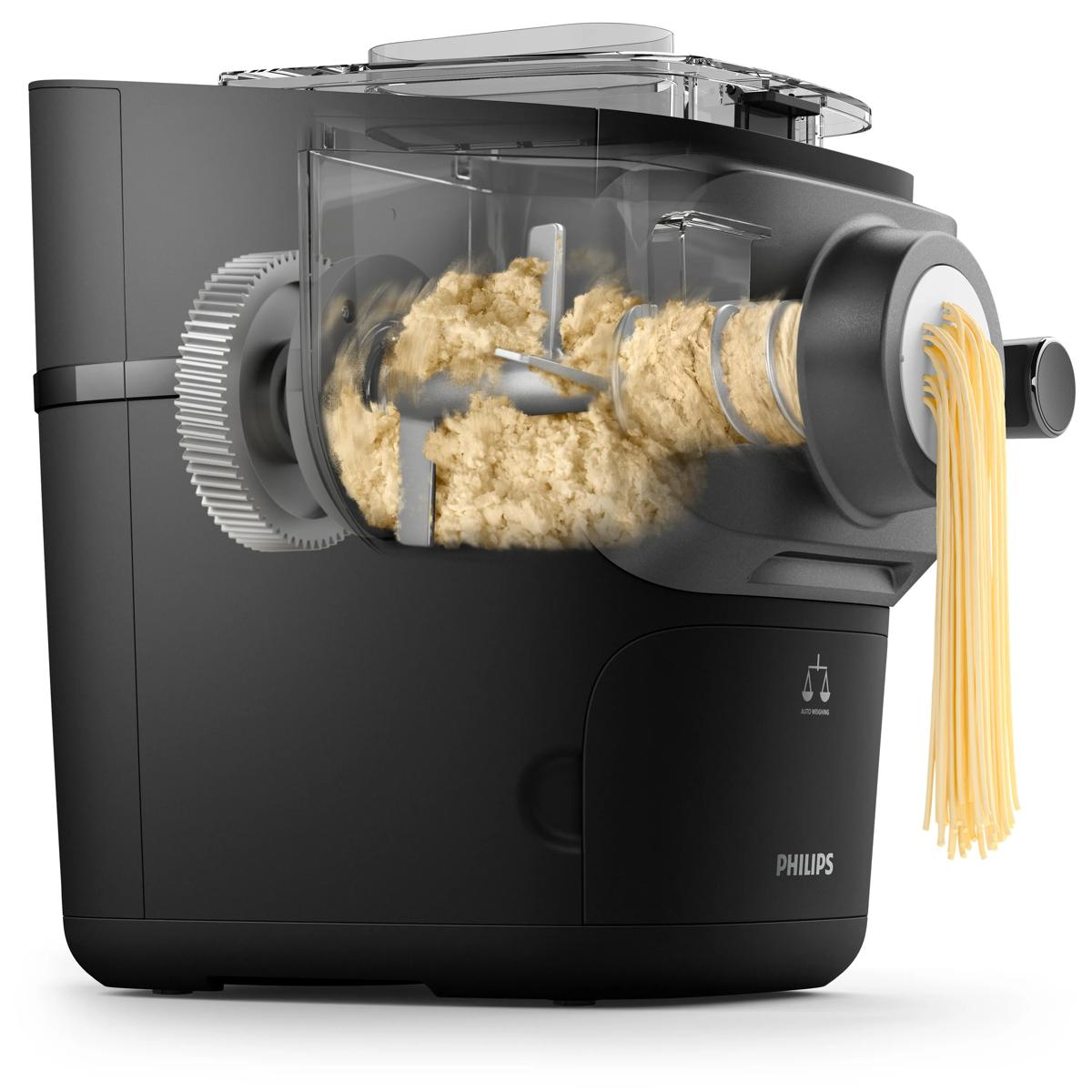 Czarna maszynka do makaronu z ciastem wyciskanym przez przezroczystą komorę, tworząc spaghetti.