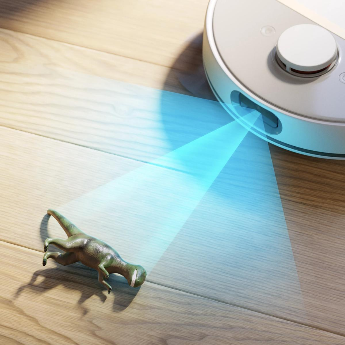 Een robotstofzuiger scant een speelgoeddinosaurus op een houten vloer met blauw licht.