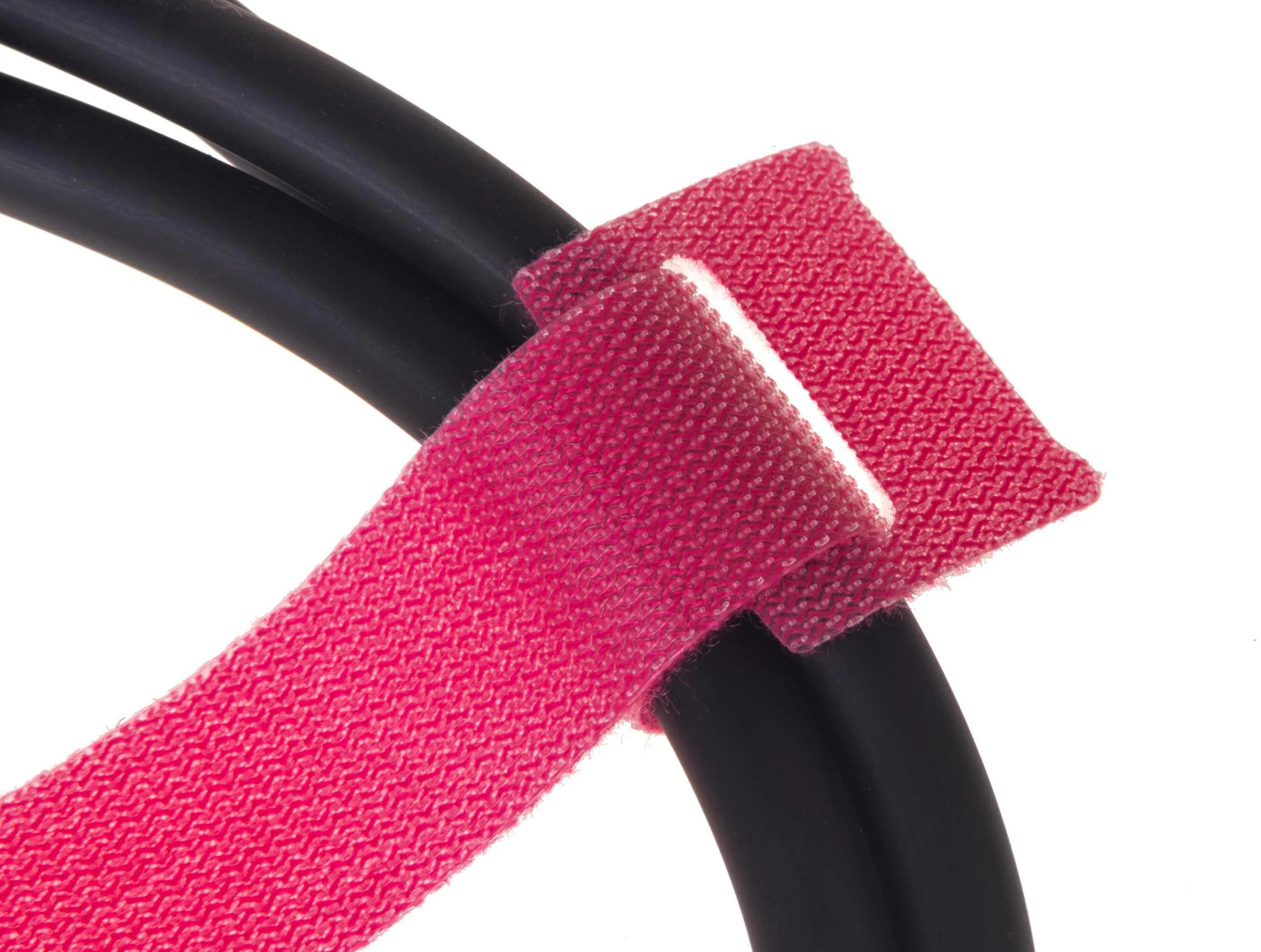 Zwei schwarze Kabel mit einem roten Klettverschluss, der sie zusammenhält.