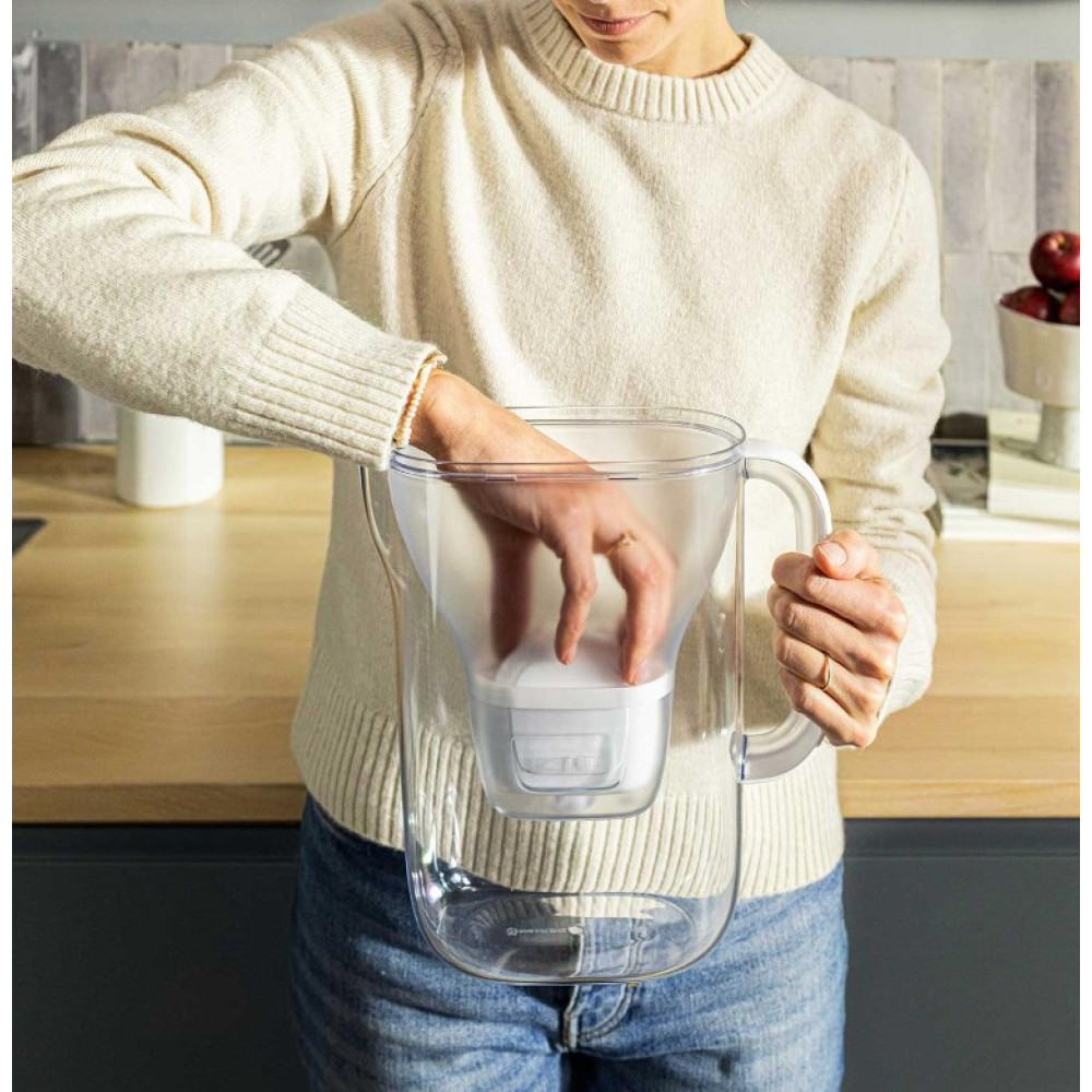 Ręka wkłada filtr do wody do przezroczystego dzbanka.