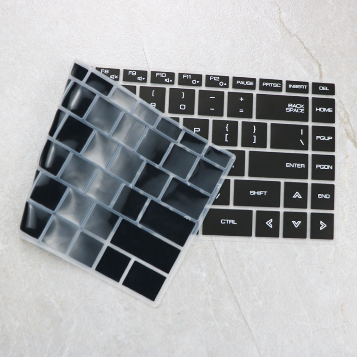 Eine durchsichtige Tastaturabdeckung liegt auf einer schwarzen Tastatur.
