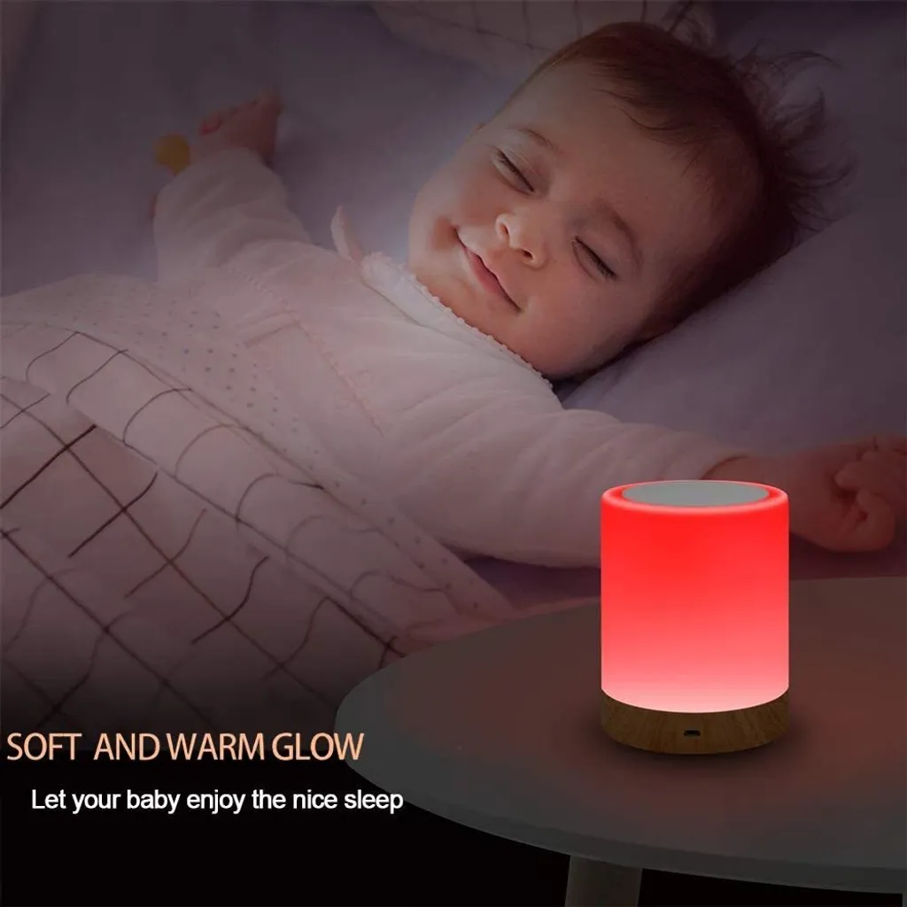 Ein Baby schläft friedlich neben einem rot leuchtenden Nachttischlampen-Würfel.