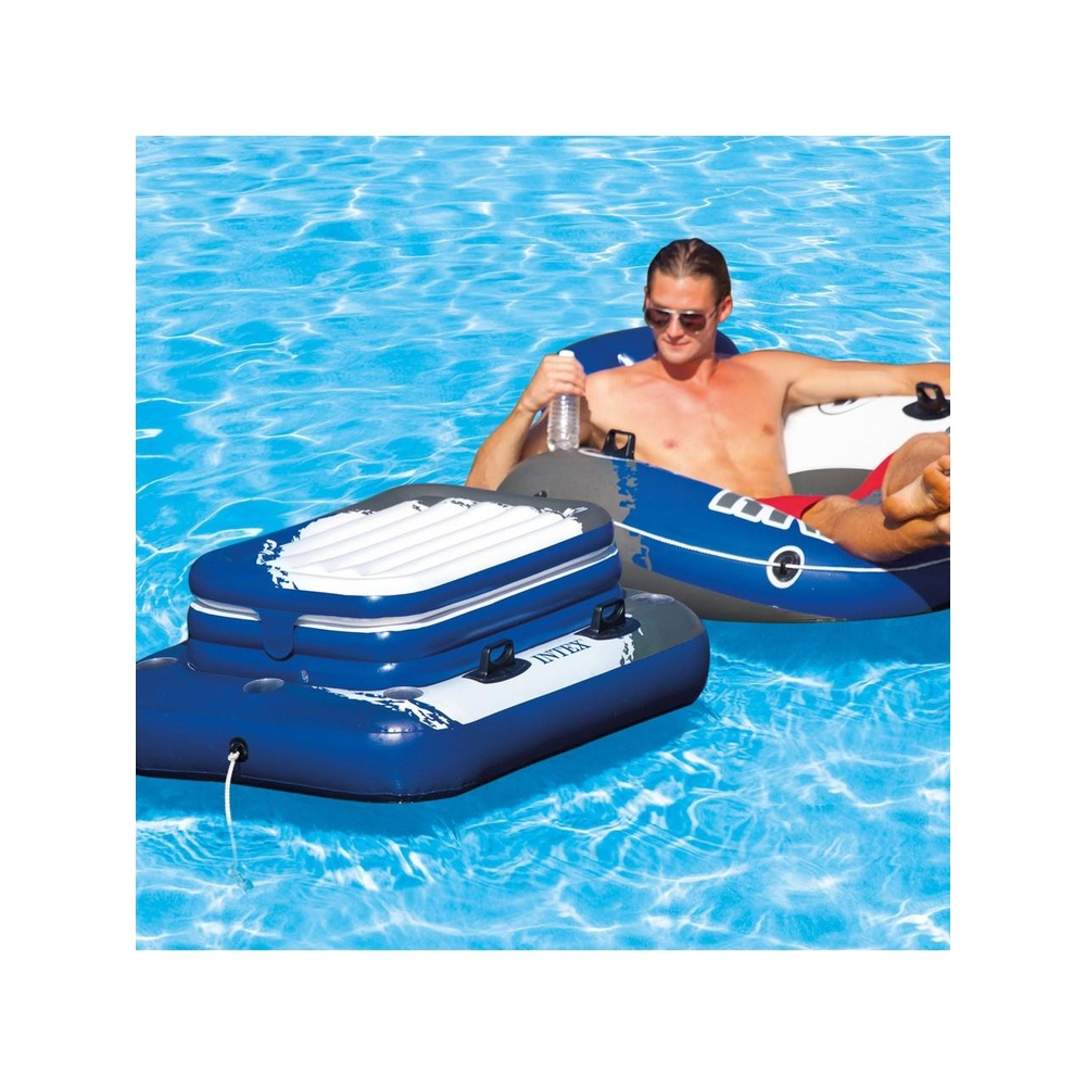 Ein Mann sitzt in einem aufblasbaren Pool-Schlauch mit einem aufblasbaren Kühler daneben.