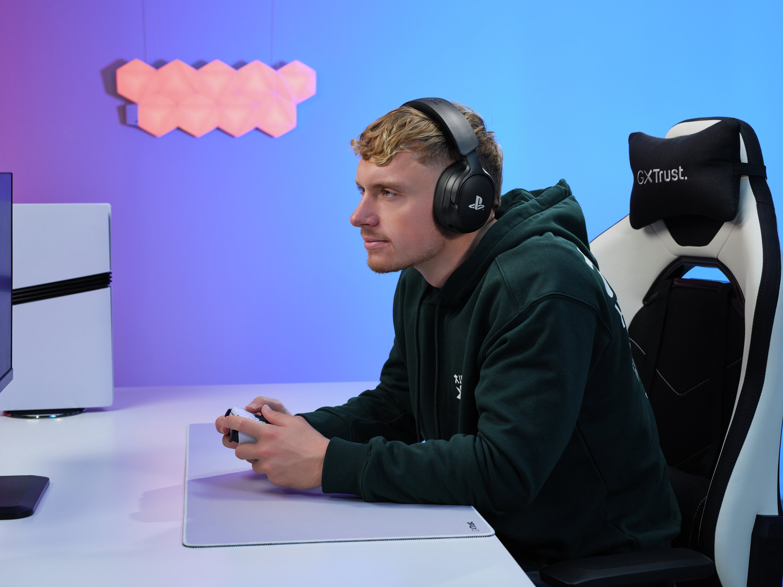 Ein Mann mit Kopfhörern spielt Videospiele in einem Gaming-Stuhl.