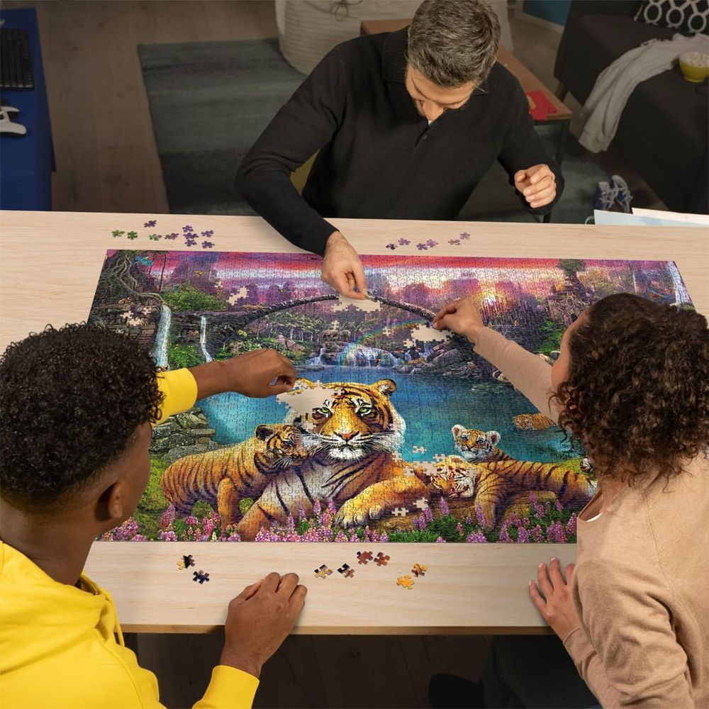 Drei Personen bauen ein Puzzlespiel mit Tigern und Wasserfällen.