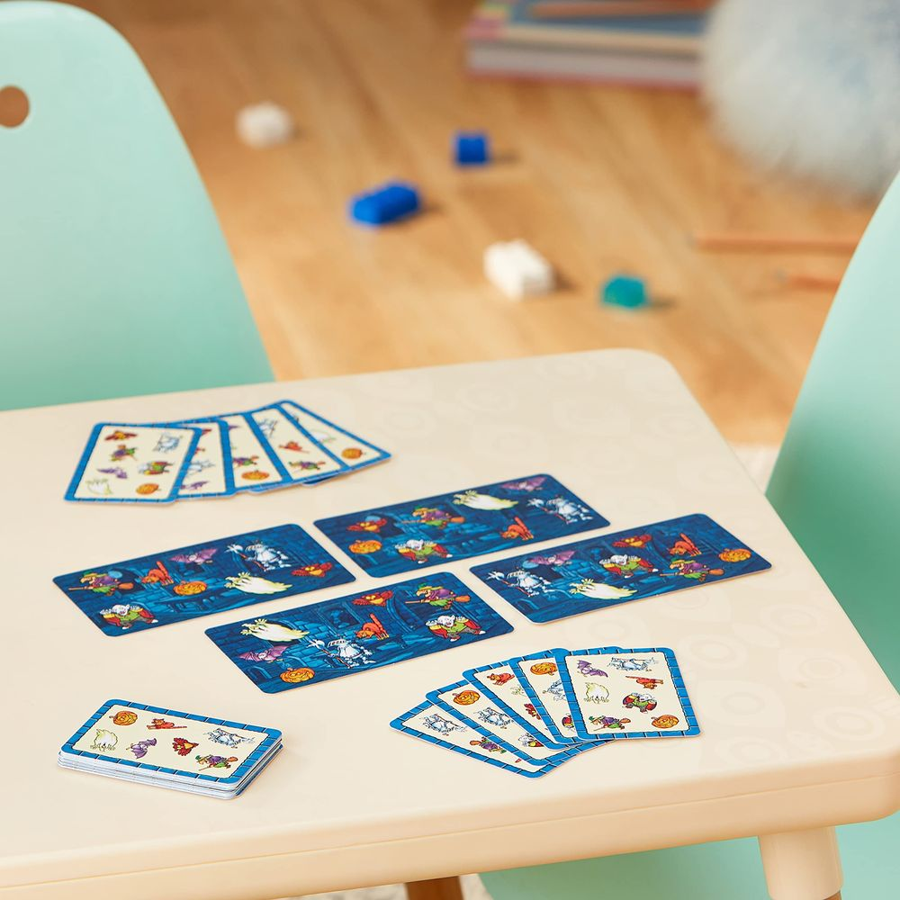 Halloween-Spielkarten mit Geistern, Kürbissen und Hexen liegen auf einem Tisch.