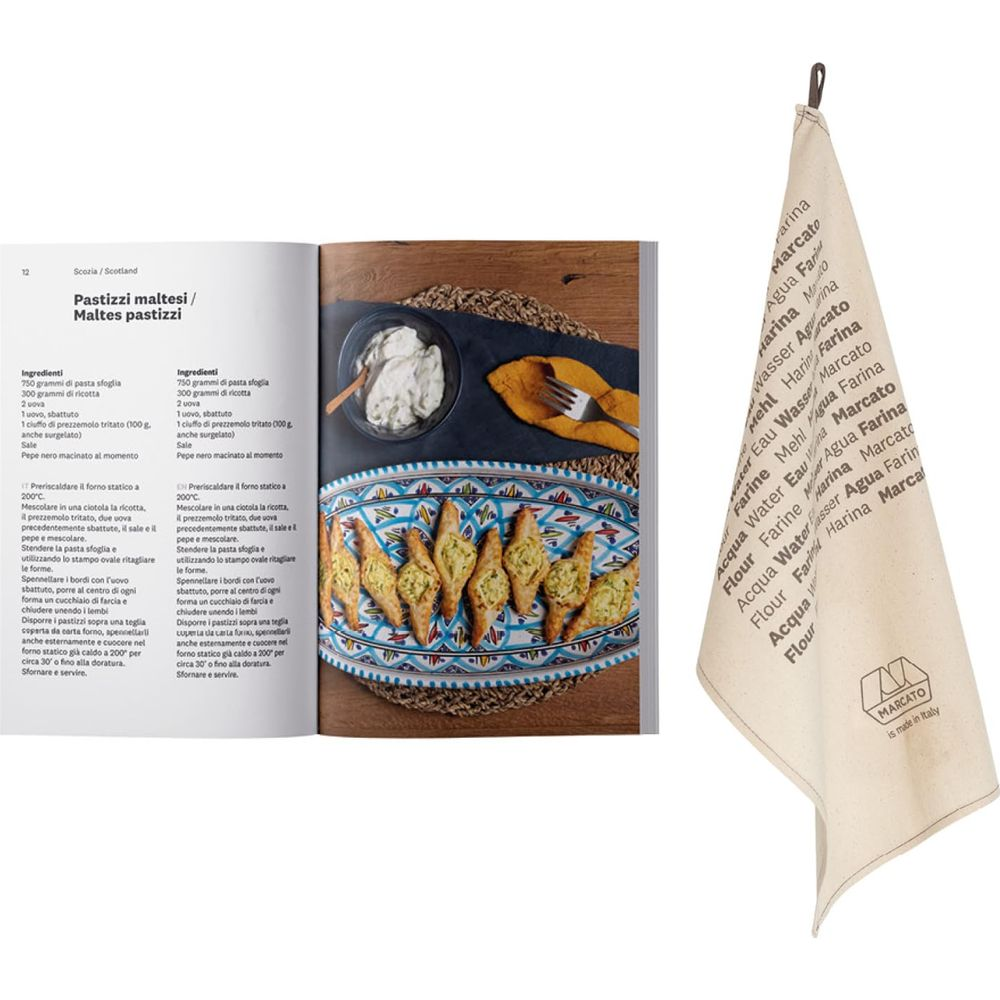 Un livre de cuisine avec recettes et un torchon avec logo "Marcato" et termes multilingues.