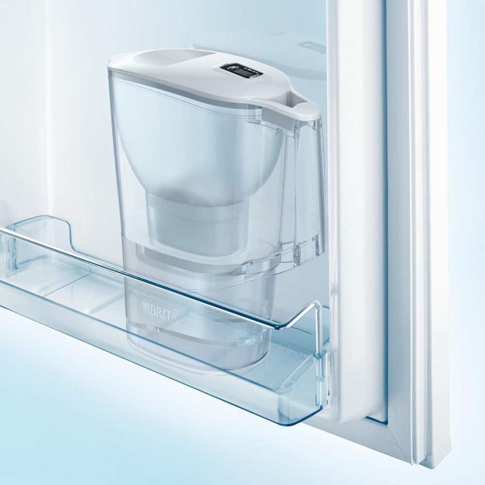 Un filtro per l'acqua Brita trasparente con indicatore digitale su uno scaffale del frigorifero.