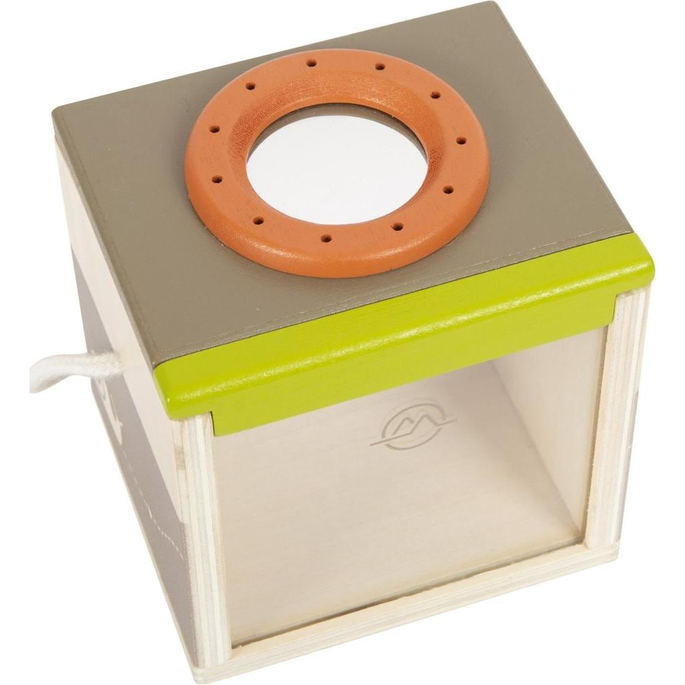 Giocattolo cubo di legno con coperchio grigio, bordo verde e lati trasparenti. Uno specchio sopra.