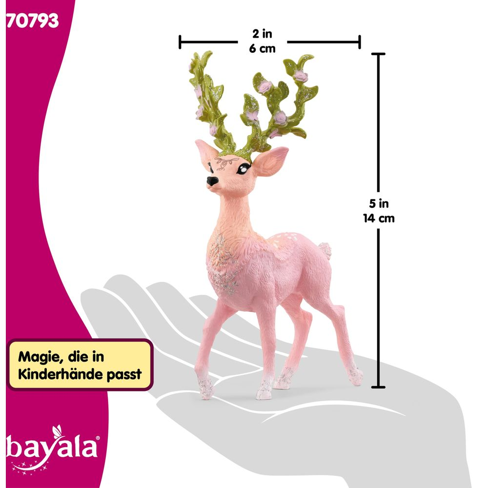 Cervo giocattolo rosa con corna floreali verdi sta su una mano grigia.
