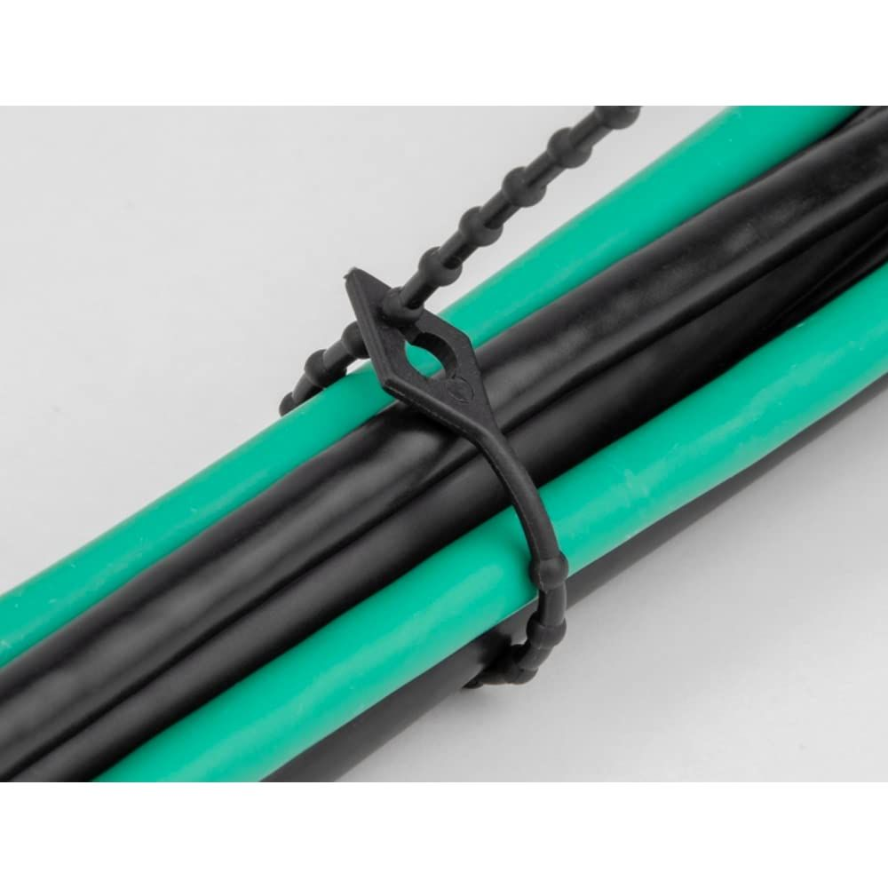 Ein schwarzes Kabelband hält mehrere grüne und schwarze Kabel zusammen.