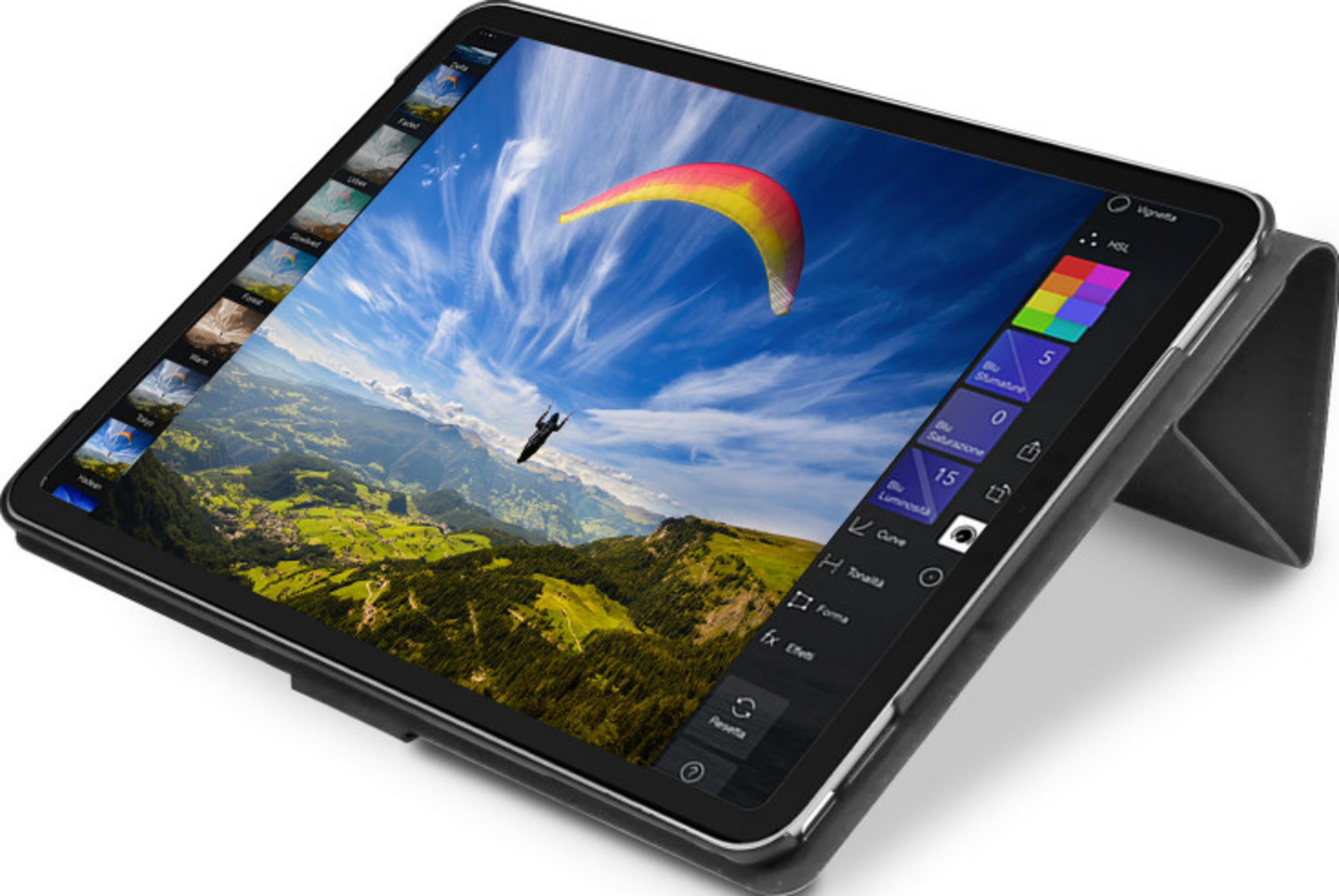Tablette avec application de retouche photo montrant un parapentiste sur paysage montagneux.