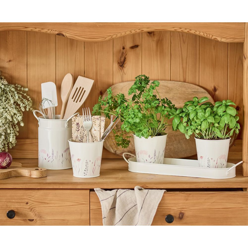 Küchenarbeitsplatte mit Utensilien in Töpfen, Kräutern und Trockenblumen. Holzschrank.