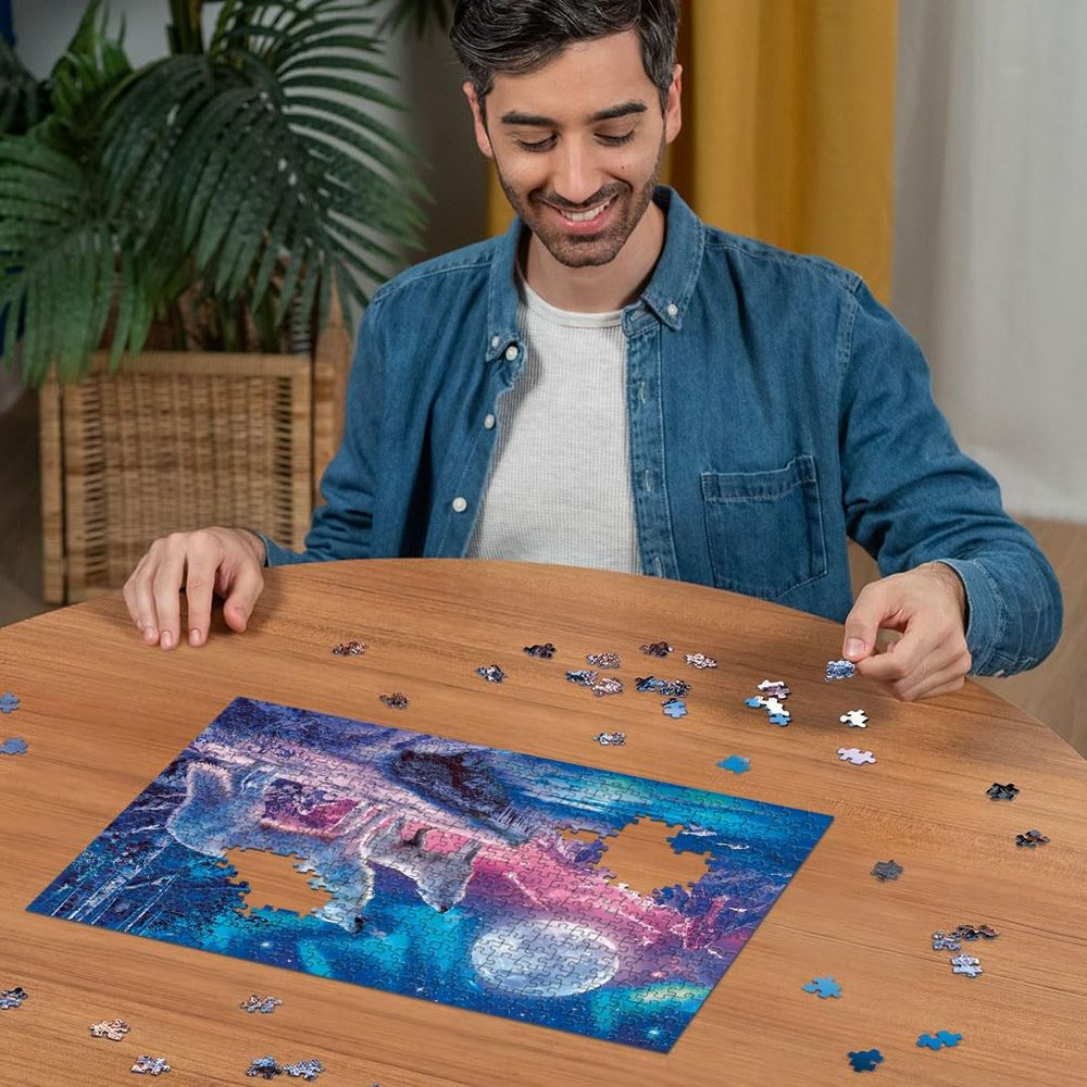 Mann setzt Puzzleteil mit Wolf-Motiv und Nordlichtern zusammen.