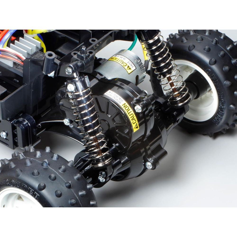 Châssis de voiture RC avec amortisseurs, moteur et roues.